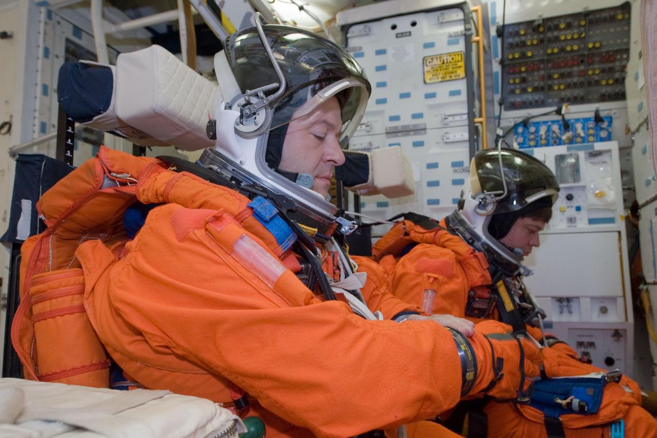 JSC2009-E-146844 (21 July 2009) --- Attired in training versions of their shuttle launch and entry suits, astronauts Nicholas Patrick (foreground) and Robert Behnken, both STS-130 mission specialists, participate in a training session on the middeck of the crew compartment trainer (CCT-2) in the Space Vehicle Mockup Facility at NASA?s Johnson Space Center.