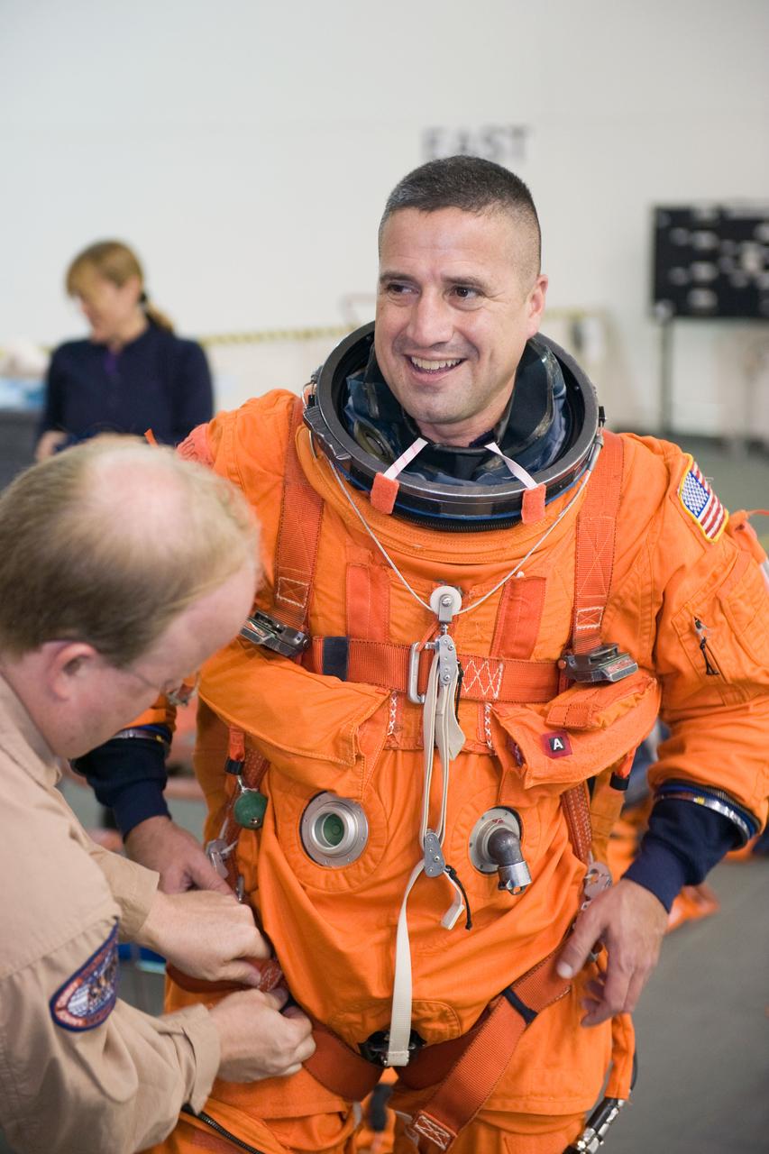 JSC2009-E-155123 (24 Aug. 2009) --- Astronaut George Zamka, STS-130 commander, dons a training version of his shuttle launch and entry suit in preparation for a water survival training session in the waters of the Neutral Buoyancy Laboratory (NBL) near NASA's Johnson Space Center. United Space Alliance suit technician Daniel Palmer assisted Zamka.