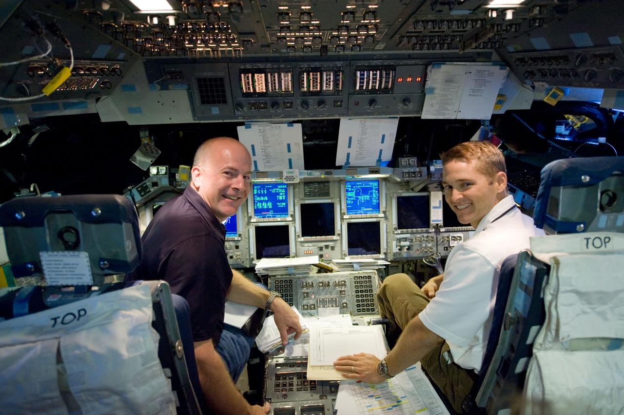JSC2009-E-207318 (11 Sept. 2009) --- NASA astronauts Alan Poindexter (left) and James P. Dutton Jr., STS-131 commander and pilot, respectively, participate in a training session in the shuttle mission simulator (SMS) in the Jake Garn Simulation and Training Facility at NASA?s Johnson Space Center.