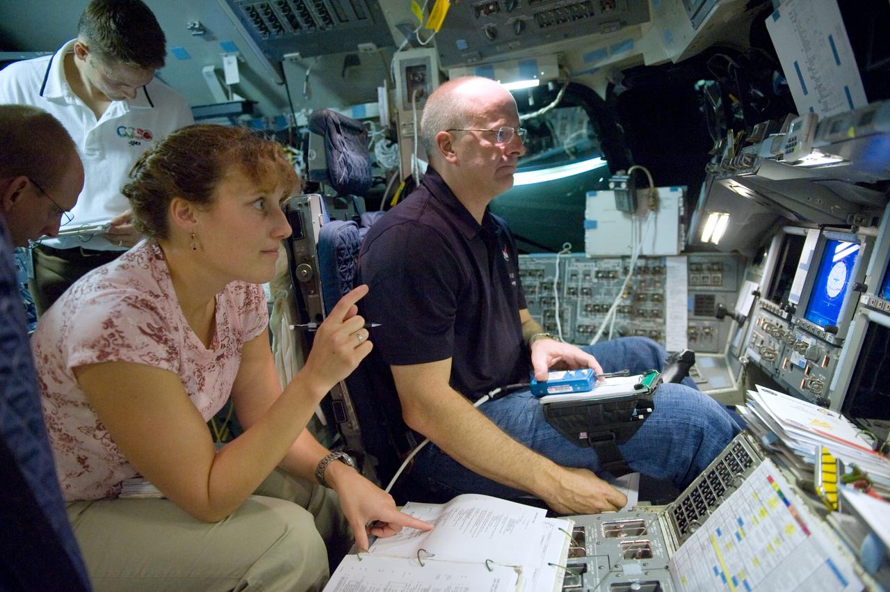 JSC2009-E-207357 (11 Sept. 2009) --- NASA astronauts Alan Poindexter (right), STS-131 commander; Dorothy Metcalf-Lindenburger and Clay Anderson (mostly out of frame at left), both mission specialists; along with James P. Dutton Jr., pilot, participate in a training session in the shuttle mission simulator (SMS) in the Jake Garn Simulation and Training Facility at NASA?s Johnson Space Center.