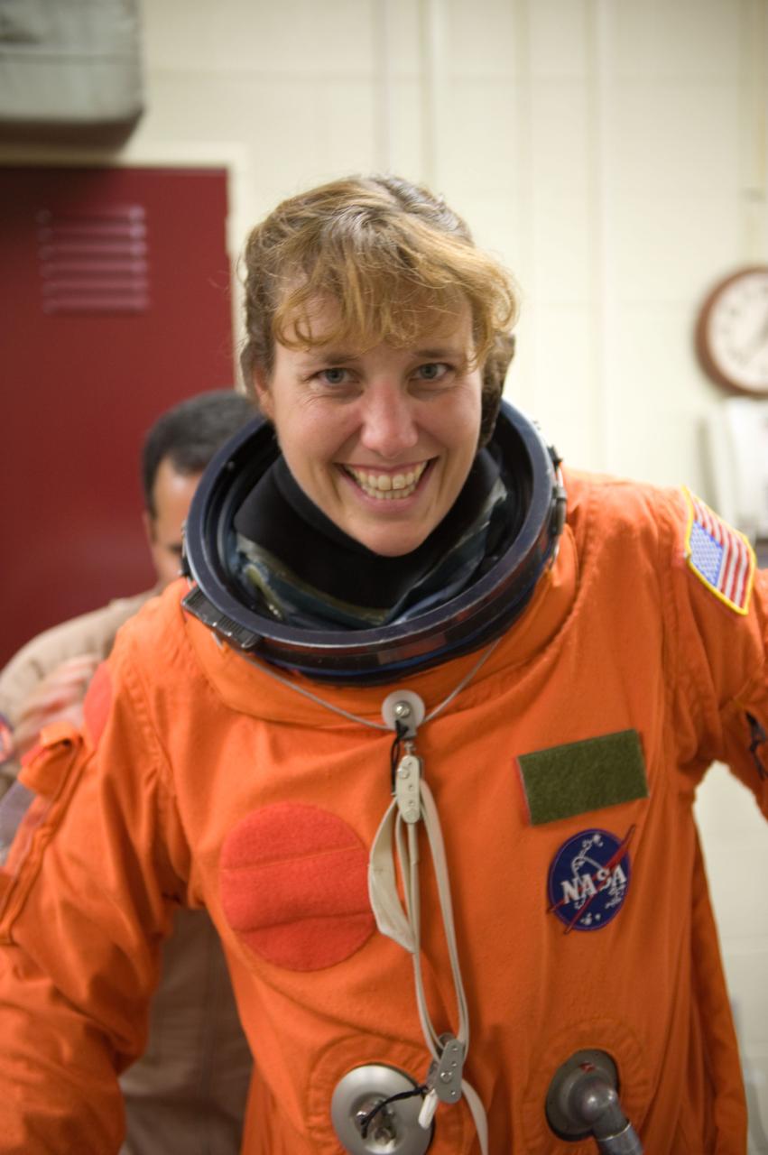 JSC2009-E-208008 (14 Sept. 2009) --- NASA astronaut Dorothy Metcalf-Lindenburger, STS-131 mission specialist, dons a training version of her shuttle launch and entry suit in preparation for a training session in the Space Vehicle Mock-up Facility at NASA's Johnson Space Center.