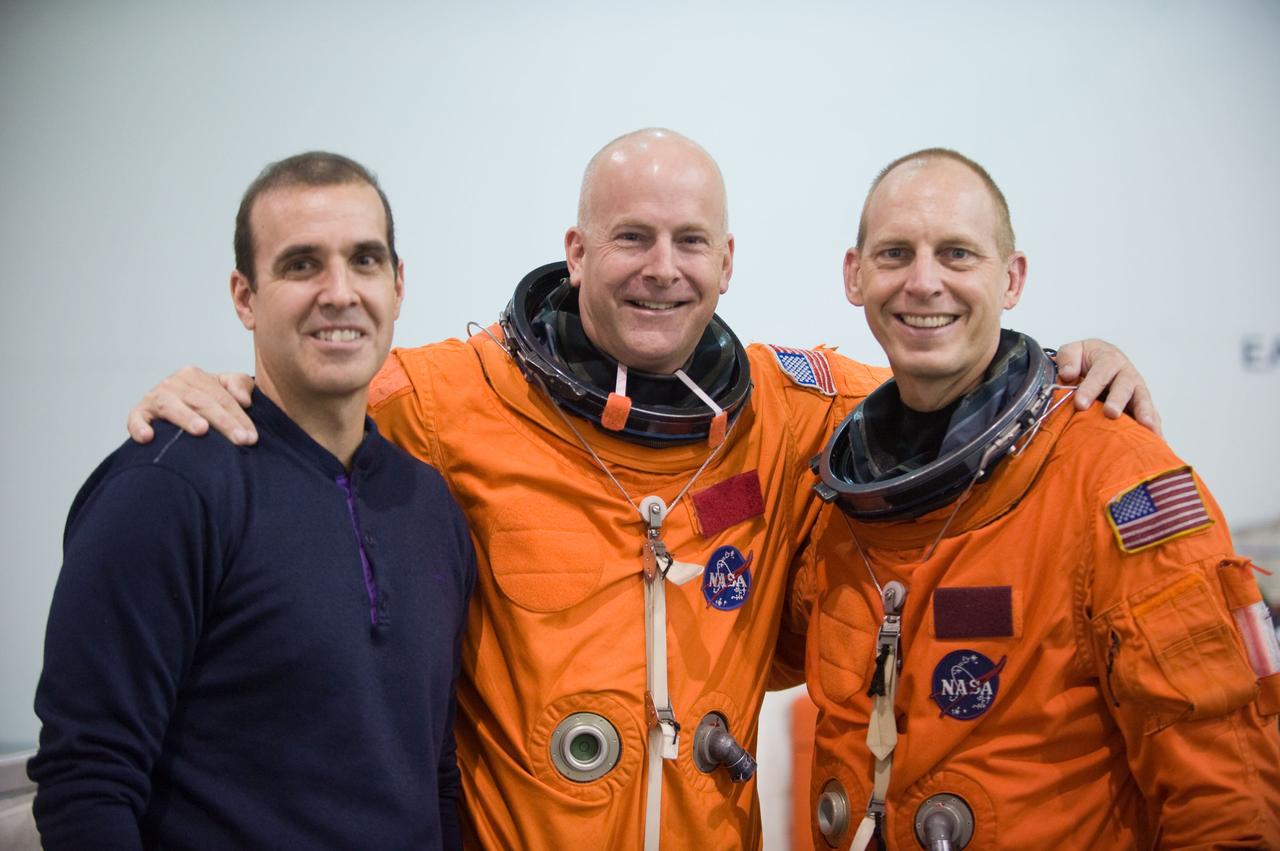JSC2009-E-208913 (17 Sept. 2009) --- NASA astronaut Alan Poindexter (center), STS-131 commander; along with astronauts Rick Mastracchio (left) and Clay Anderson, both mission specialists, take a brief break for a photo during a water survival training session in the Neutral Buoyancy Laboratory (NBL) near NASA's Johnson Space Center. Poindexter and Anderson are attired in training versions of their shuttle launch and entry suits.