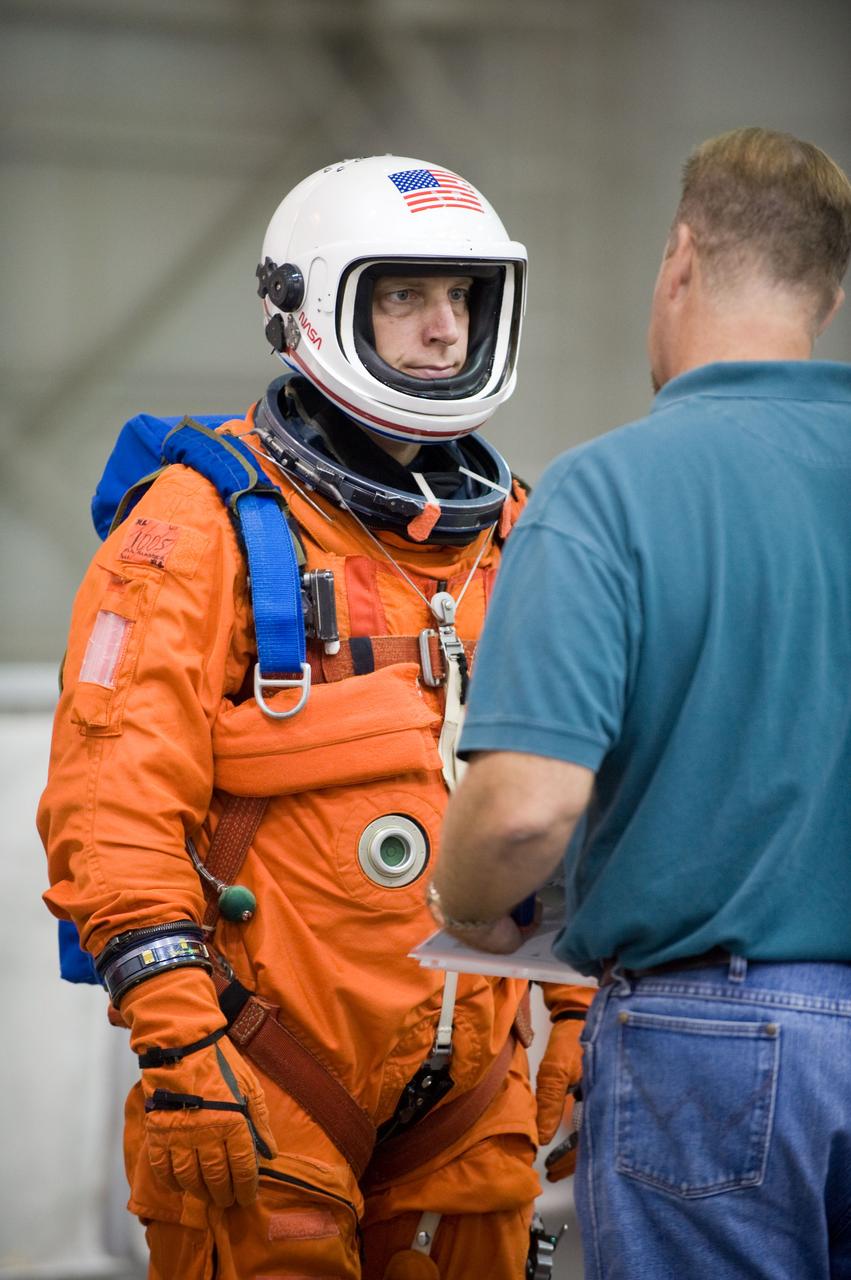 JSC2009-E-208970 (17 Sept. 2009) --- United Space Alliance crew trainer Robert (Rob) Tomaro (right) briefs NASA astronaut Clay Anderson, STS-131 mission specialist, in preparation for a water survival training session in the waters of the Neutral Buoyancy Laboratory (NBL) near NASA's Johnson Space Center. Anderson is wearing a training version of his shuttle launch and entry suit.