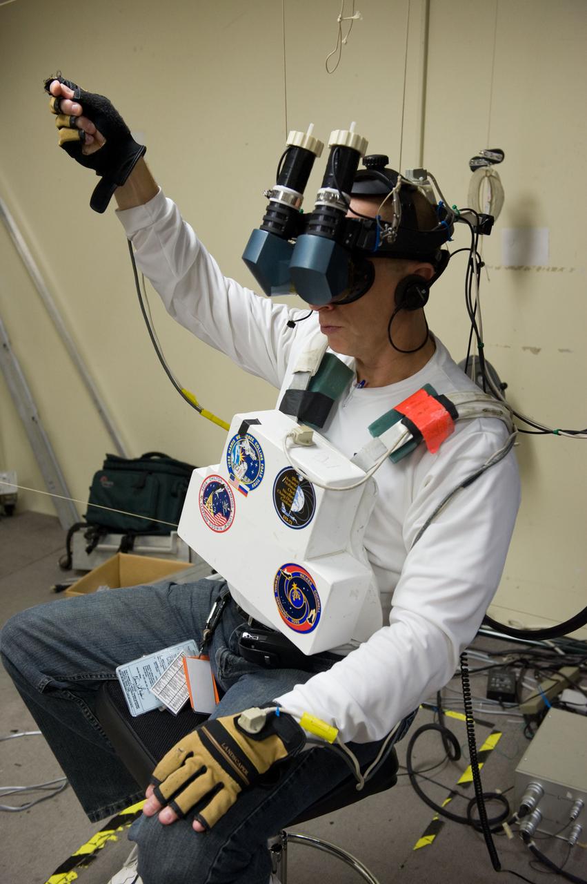 JSC2009-E-214340 (25 Sept. 2009) --- NASA astronaut Clayton Anderson, STS-131 mission specialist, uses virtual reality hardware in the Space Vehicle Mock-up Facility at NASA's Johnson Space Center to rehearse some of his duties on the upcoming mission to the International Space Station. This type of virtual reality training allows the astronauts to wear a helmet and special gloves while looking at computer displays simulating actual movements around the various locations on the station hardware with which they will be working.