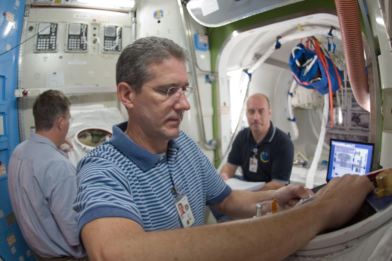 JSC2009-E-214810 (29 Sept. 2009) --- Astronauts Mike Good (foreground), Steve Bowen (left and Garrett Reisman, all STS-132 mission specialists, participate in a training session in an International Space Station mock-up/trainer in the Space Vehicle Mock-up Facility at NASA's Johnson Space Center.
