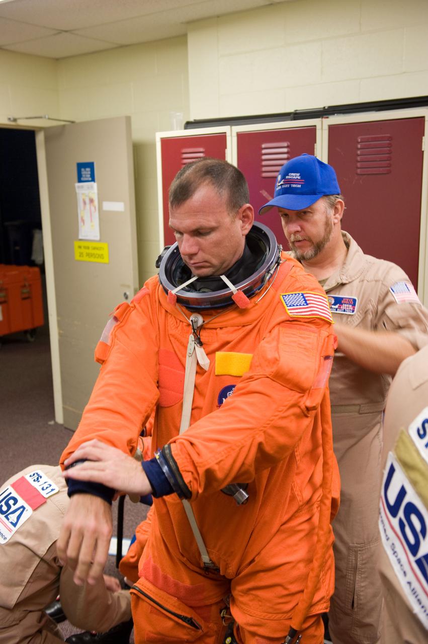 JSC2009-E-224113 (20 Oct. 2009) --- Astronaut Tony Antonelli, STS-132 pilot, dons a training version of his shuttle launch and entry suit in preparation for a training session in the Space Vehicle Mock-up Facility at NASA's Johnson Space Center. United Space Alliance suit technician Steve Sholtz assisted Antonelli.