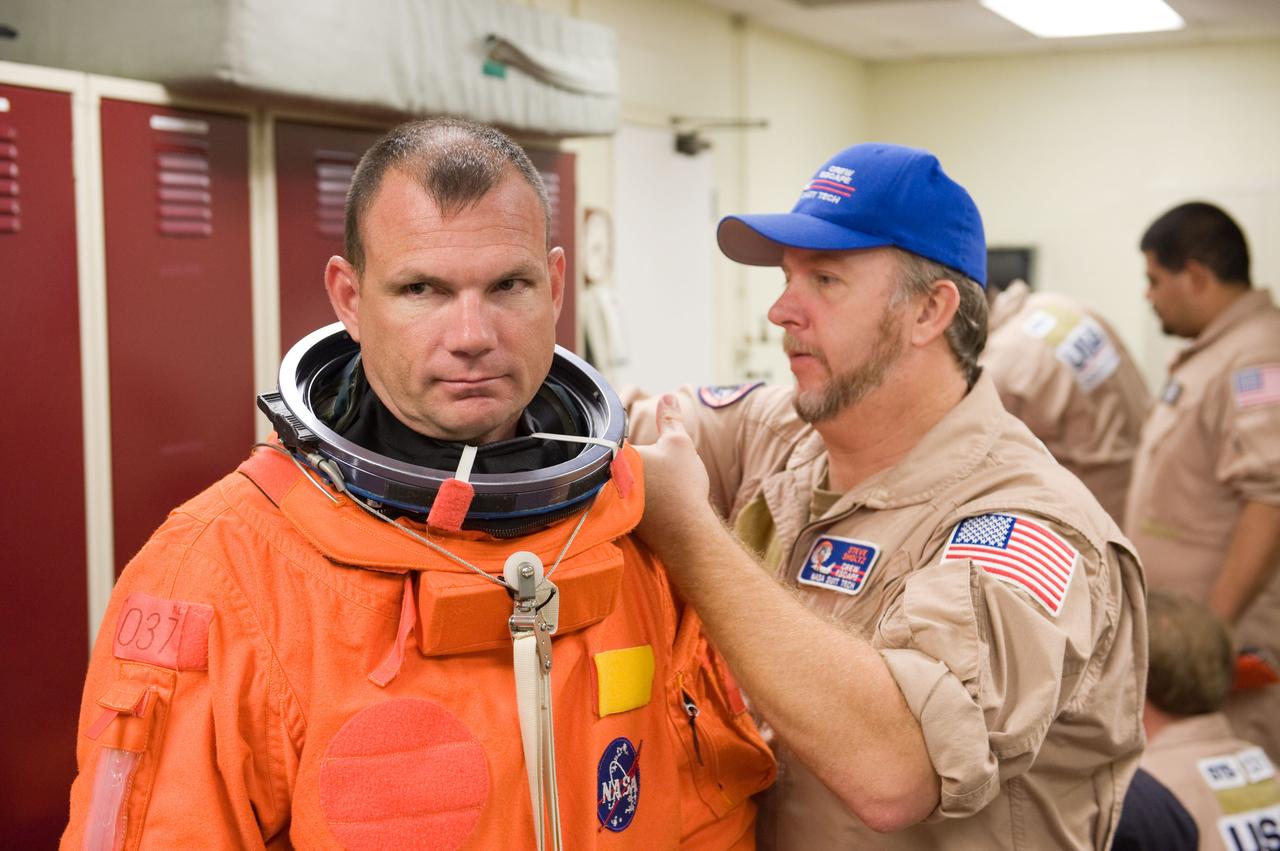 JSC2009-E-224117 (20 Oct. 2009) --- Astronaut Tony Antonelli, STS-132 pilot, dons a training version of his shuttle launch and entry suit in preparation for a training session in the Space Vehicle Mock-up Facility at NASA's Johnson Space Center. United Space Alliance suit technician Steve Sholtz assisted Antonelli.