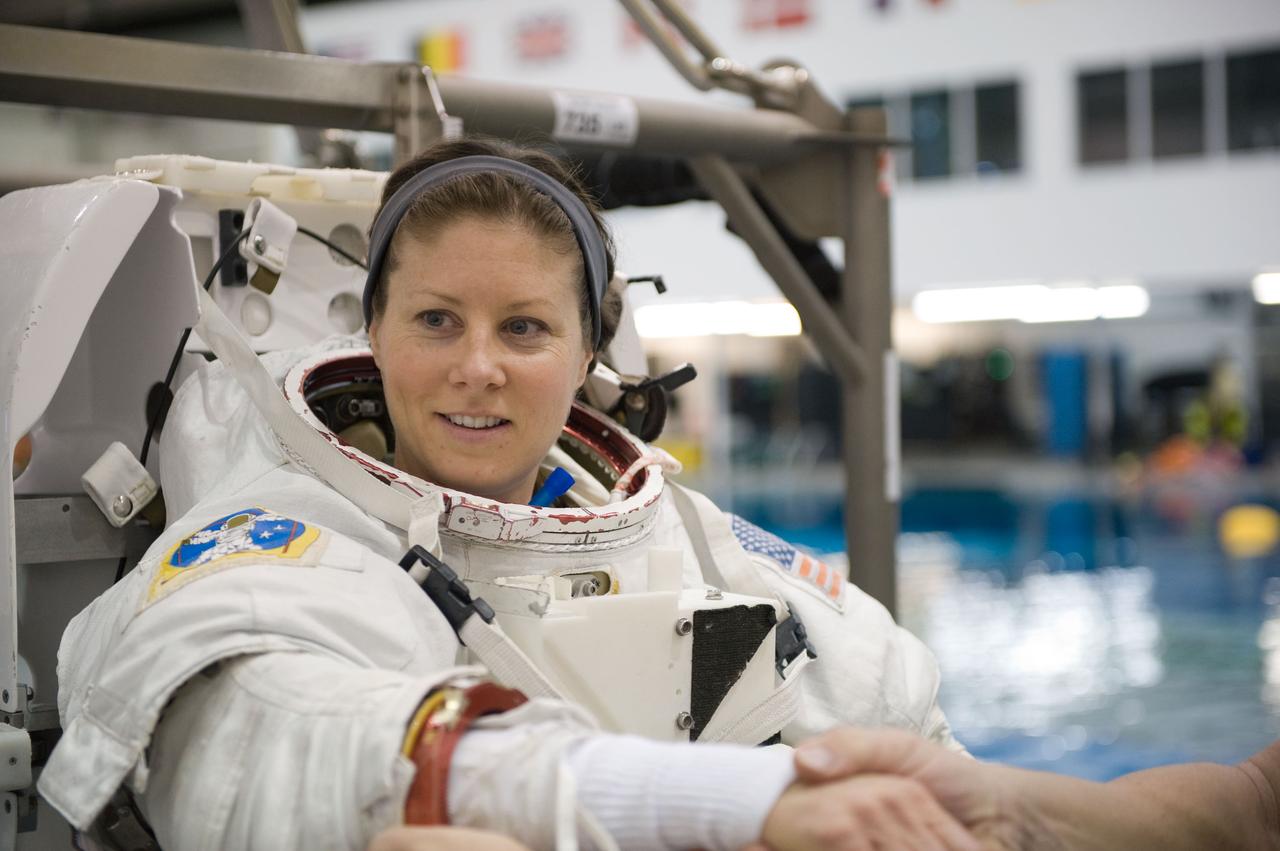 JSC2009-E-226213 (28 Oct. 2009) --- Astronaut Tracy Caldwell, Expedition 23/24 flight engineer, gets help in the donning of a training version of her Extravehicular Mobility Unit (EMU) spacesuit in preparation for a spacewalk training session in the waters of the Neutral Buoyancy Laboratory (NBL) near NASA's Johnson Space Center.