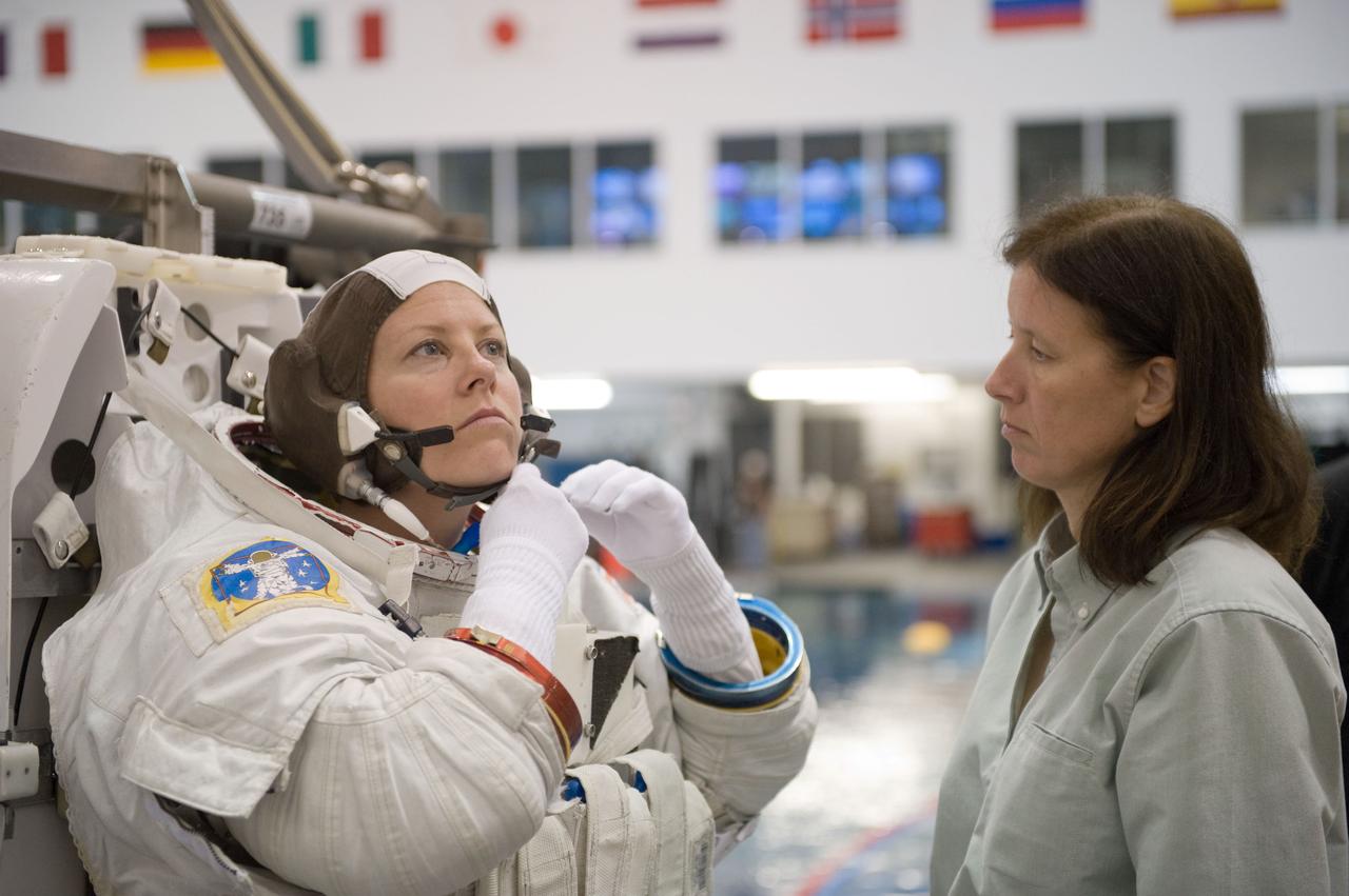 JSC2009-E-226223 (28 Oct. 2009) --- Astronaut Tracy Caldwell, Expedition 23/24 flight engineer, dons a training version of her Extravehicular Mobility Unit (EMU) spacesuit in preparation for a spacewalk training session in the waters of the Neutral Buoyancy Laboratory (NBL) near NASA's Johnson Space Center. Astronaut Shannon Walker, Expedition 24/25 flight engineer, assisted Caldwell.