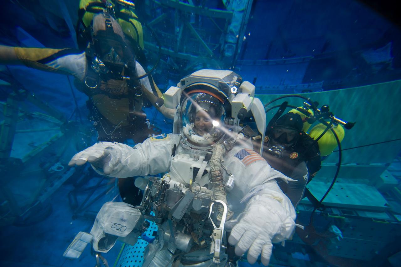 JSC2009-E-226239 (28 Oct. 2009) --- Astronaut Tracy Caldwell, Expedition 23/24 flight engineer, attired in a training version of her Extravehicular Mobility Unit (EMU) spacesuit, participates in a spacewalk training session in the waters of the Neutral Buoyancy Laboratory (NBL) near NASA's Johnson Space Center. Divers are in the water to assist Caldwell in her rehearsal, which is intended to help prepare her for work on the exterior of the International Space Station.