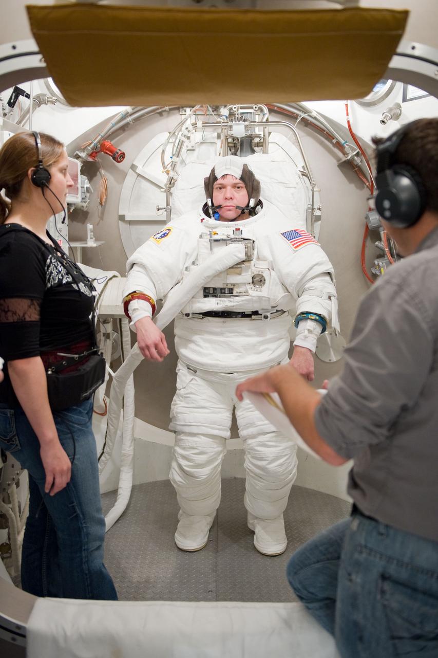 JSC2009-E-226276 (27 Oct. 2009) --- Astronaut Robert Behnken, STS-130 mission specialist, participates in an Extravehicular Mobility Unit (EMU) spacesuit fit check in the Space Station Airlock Test Article (SSATA) in the Crew Systems Laboratory at NASA's Johnson Space Center. Test directors assisted Behnken.