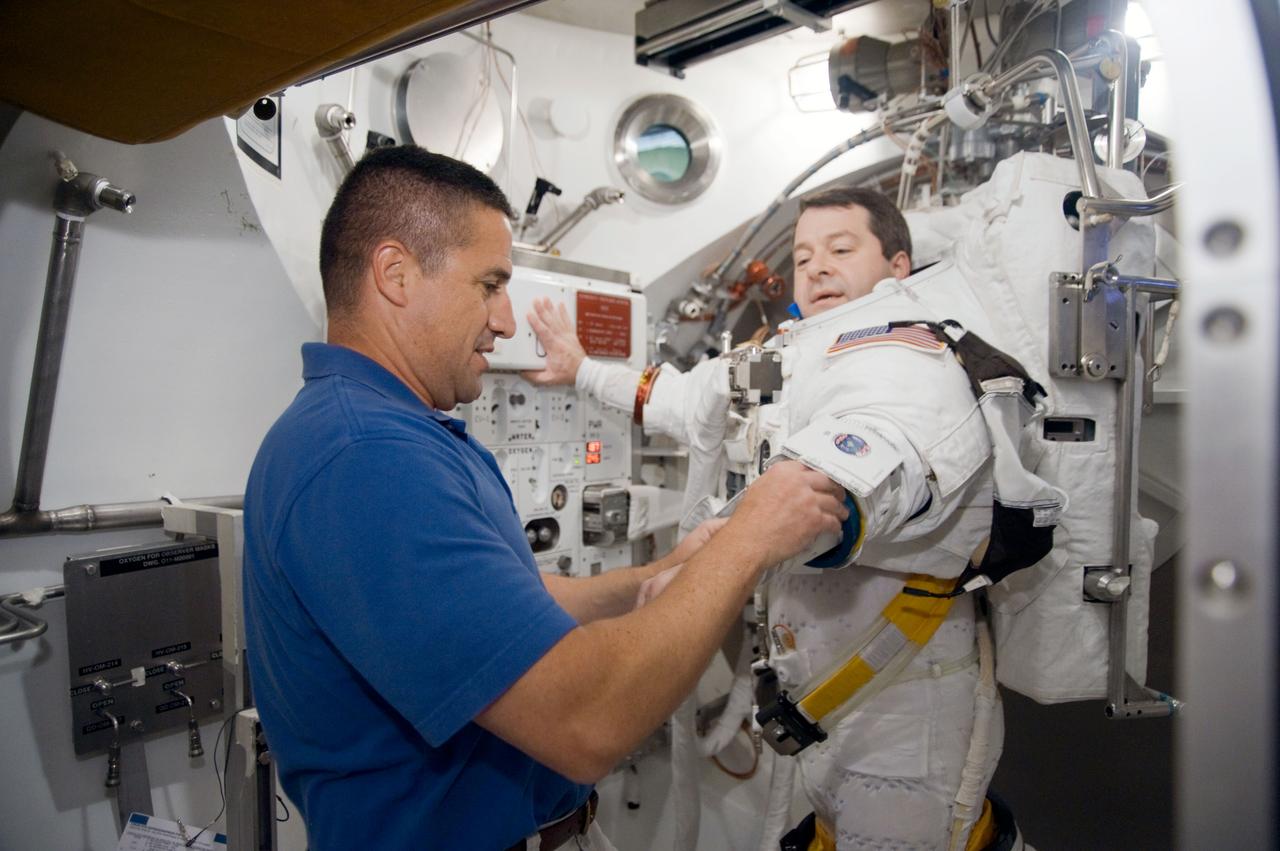 JSC2009-E-228742 (29 Oct. 2009) --- Astronaut Nicholas Patrick, STS-130 mission specialist, participates in an Extravehicular Mobility Unit (EMU) spacesuit fit check in the Space Station Airlock Test Article (SSATA) in the Crew Systems Laboratory at NASA's Johnson Space Center. Astronaut George Zamka, commander, assisted Patrick.