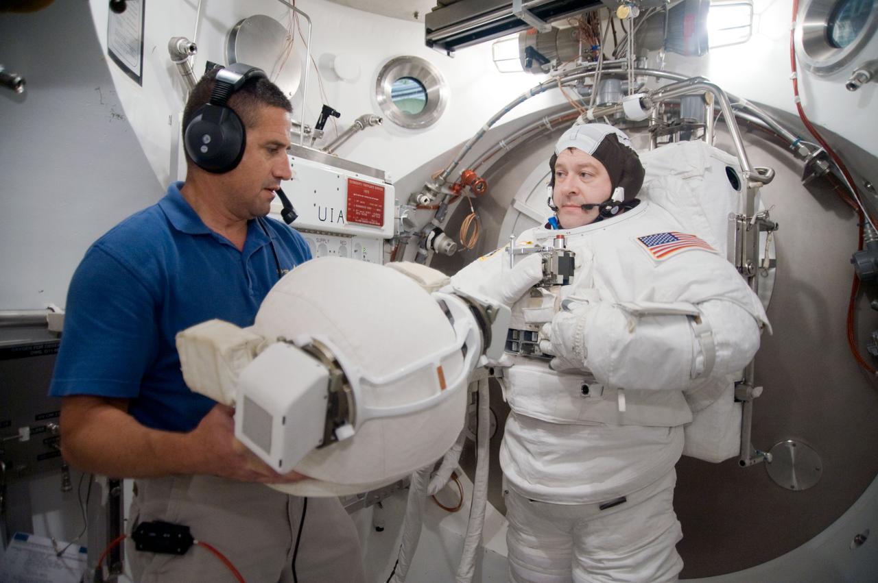 JSC2009-E-228755 (29 Oct. 2009) --- Astronaut Nicholas Patrick, STS-130 mission specialist, participates in an Extravehicular Mobility Unit (EMU) spacesuit fit check in the Space Station Airlock Test Article (SSATA) in the Crew Systems Laboratory at NASA's Johnson Space Center. Astronaut George Zamka, commander, assisted Patrick.