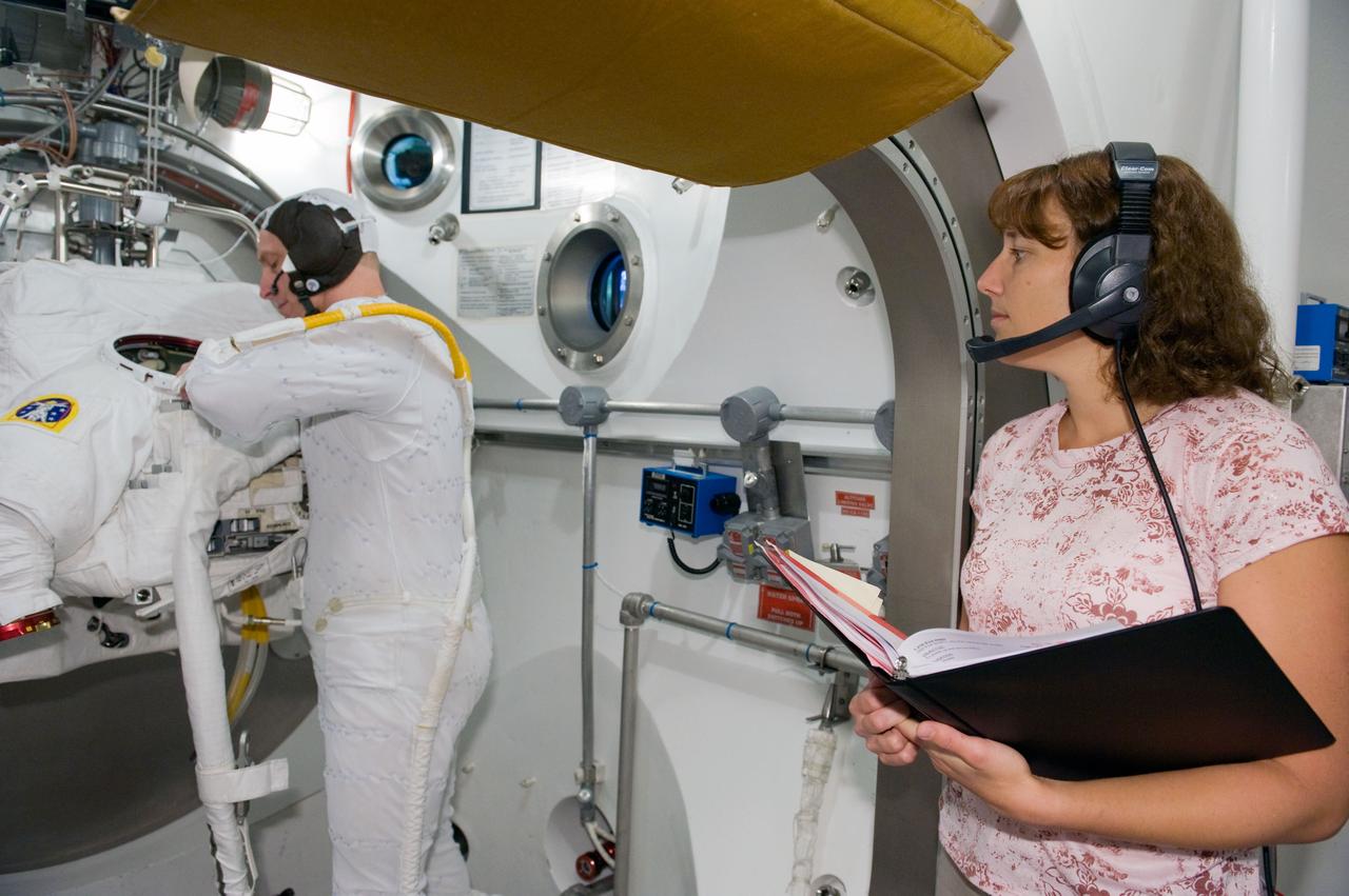 JSC2009-E-240473 (5 Nov. 2009) --- Astronaut Clayton Anderson, STS-131 mission specialist, participates in an Extravehicular Mobility Unit (EMU) spacesuit fit check in the Space Station Airlock Test Article (SSATA) in the Crew Systems Laboratory at NASA's Johnson Space Center. Astronaut Dorothy Metcalf-Lindenburger, mission specialist, assisted Anderson.