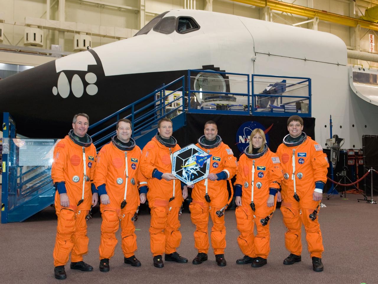 JSC2009-E-242830 (19 Nov. 2009) --- The STS-130 crew members, attired in training versions of their shuttle launch and entry suits, take a moment to pose for a crew photo prior to a training session in the Space Vehicle Mockup Facility at NASA's Johnson Space Center. Astronauts George Zamka (center right), commander; and Terry Virts, pilot, hold the mission logo. Also pictured from the left are astronauts Stephen Robinson, Nicholas Patrick, Kathryn Hire and Robert Behnken, all mission specialists.