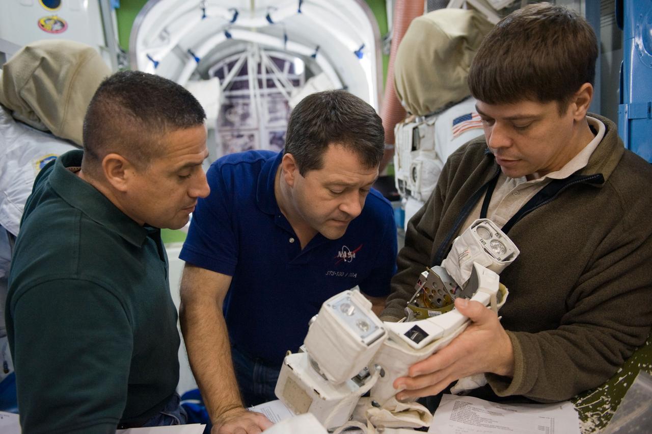 JSC2009-E-244234 (23 Nov. 2009) --- Astronaut George Zamka (left), STS-130 commander; along with astronauts Nicholas Patrick (center) and Robert Behnken, both mission specialists, work with Extravehicular Mobility Unit (EMU) spacesuit equipment during a training session in an International Space Station mock-up/trainer in the Space Vehicle Mock-up Facility at NASA's Johnson Space Center.