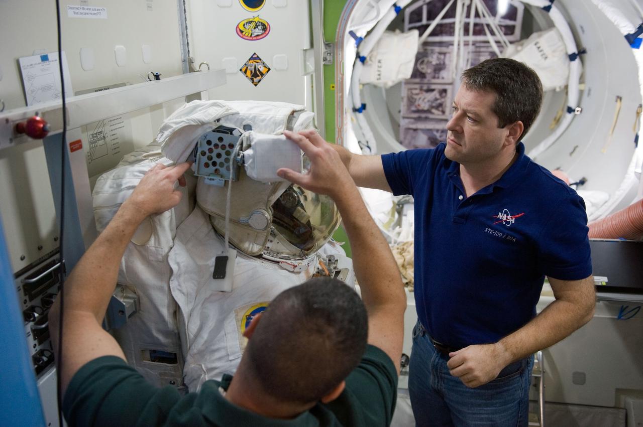 JSC2009-E-244235 (23 Nov. 2009) --- Astronaut George Zamka (foreground), STS-130 commander; and astronaut Nicholas Patrick, mission specialist, work with an Extravehicular Mobility Unit (EMU) spacesuit during a training session in an International Space Station mock-up/trainer in the Space Vehicle Mock-up Facility at NASA's Johnson Space Center.