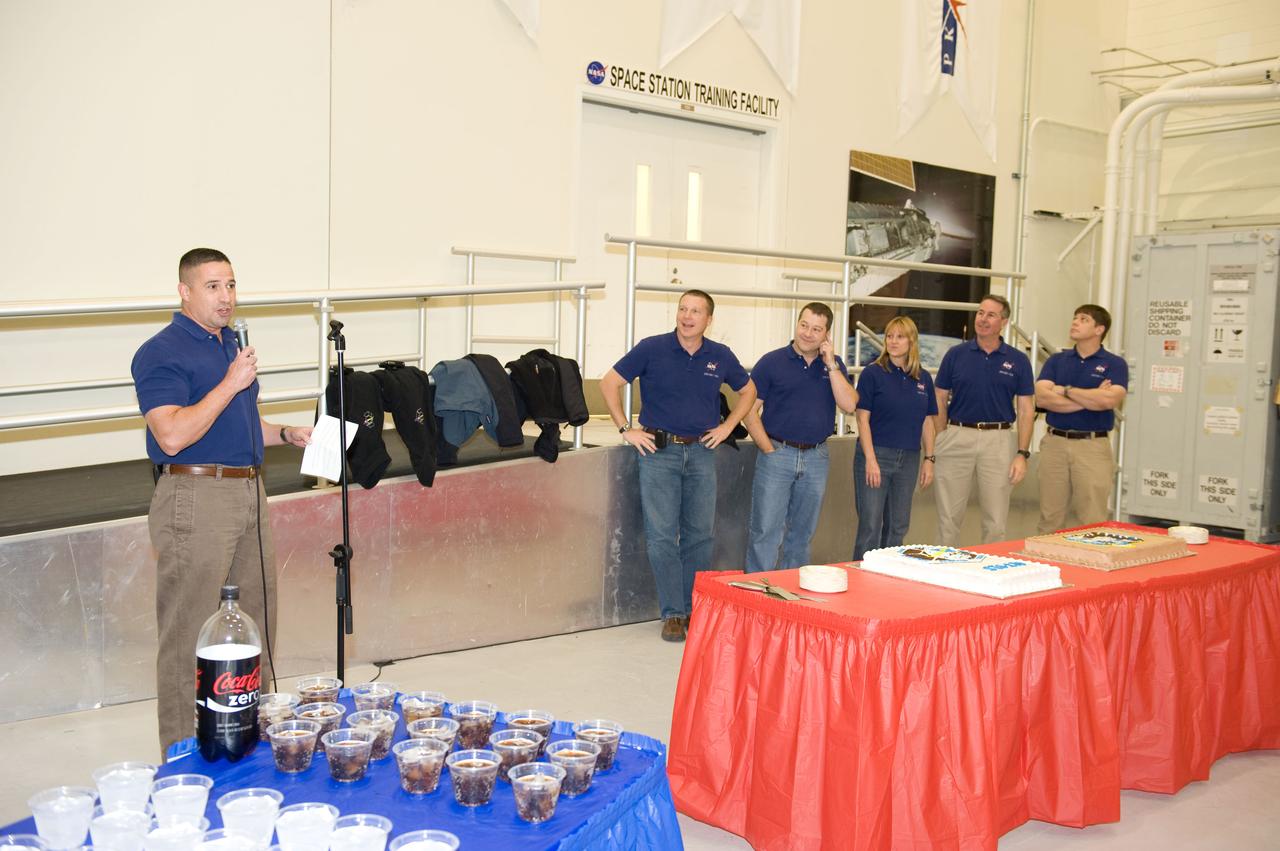 JSC2009-E-246194 (2 Dec. 2009) --- Astronaut George Zamka (left), STS-130 commander, speaks to a crowd during a cake-cutting ceremony in the Jake Garn Simulation and Training Facility at NASA's Johnson Space Center. Also pictured are astronauts Terry Virts, pilot; along with Nicholas Patrick, Kathryn Hire, Stephen Robinson and Robert Behnken, all mission specialists.oyos