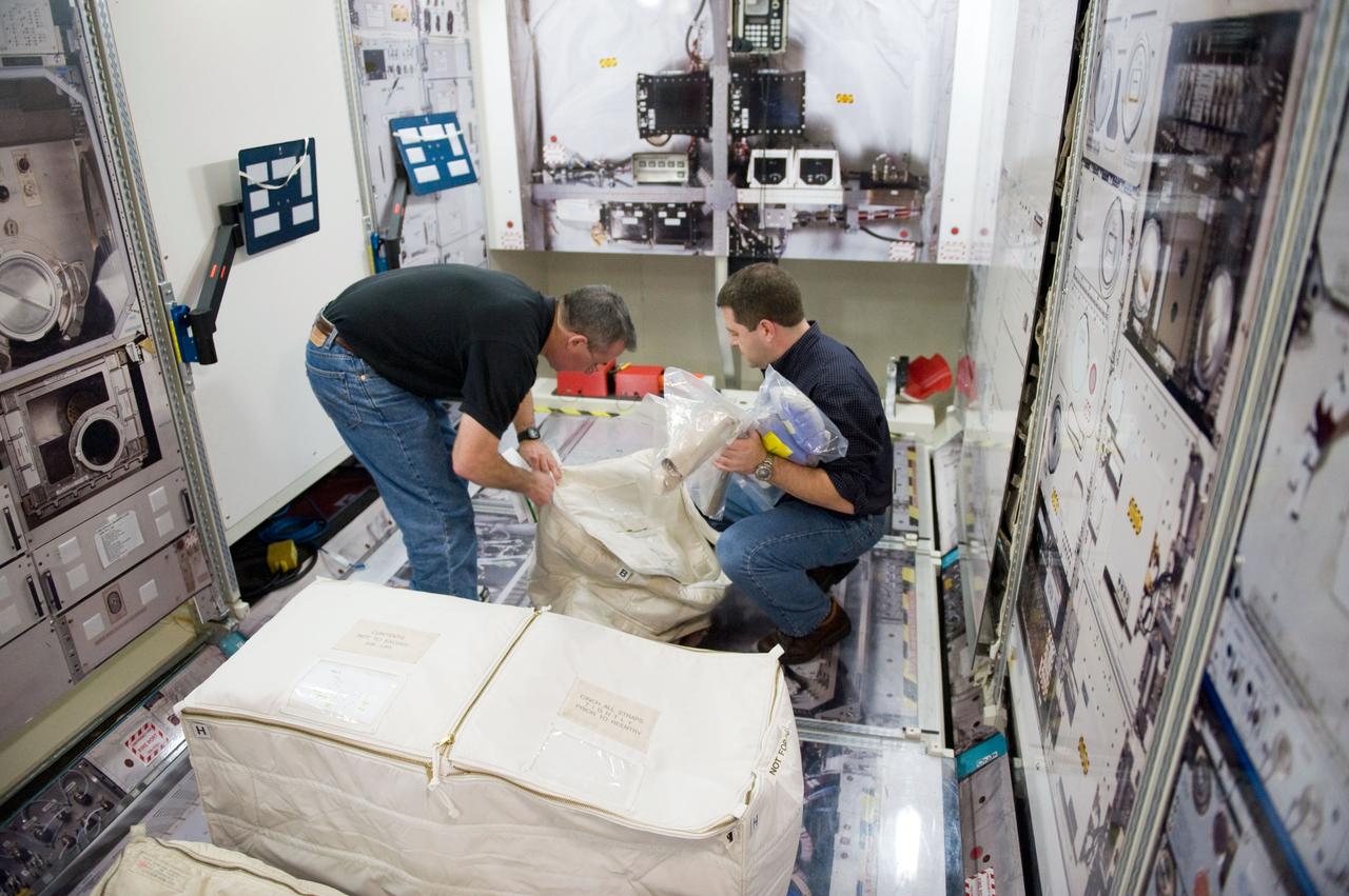 JSC2009-E-258408 (8 Dec. 2009) --- Astronauts Stephen Robinson (left) and Nicholas Patrick, both STS-130 mission specialists, participate in a training session in an International Space Station mock-up/trainer in the Space Vehicle Mock-up Facility at NASA's Johnson Space Center.