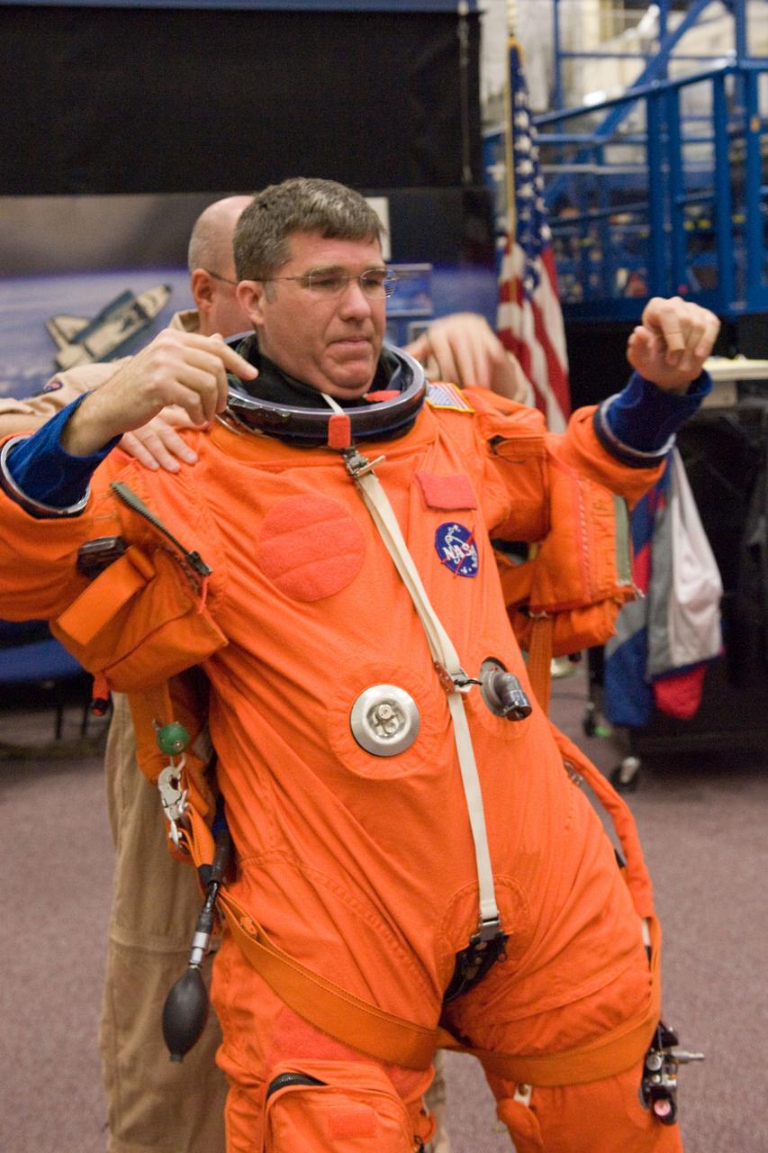 JSC2009-E-258453 (8 Dec. 2009) --- Astronaut Steve Bowen, STS-132 mission specialist, gets help in the donning of a training version of his shuttle launch and entry suit in preparation for a training session in the Space Vehicle Mock-up Facility at NASA's Johnson Space Center.