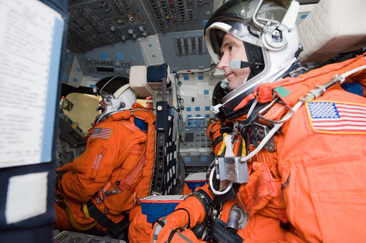 JSC2009-E-258462 (8 Dec. 2009) --- Astronauts Mike Good (foreground), STS-130 mission specialist; and Tony Antonelli, pilot, participate in a post insertion/de-orbit training session in the crew compartment trainer (CCT-2) in the Space Vehicle Mockup Facility at NASA's Johnson Space Center. Antonelli and Good are wearing training versions of their shuttle launch and entry suits.