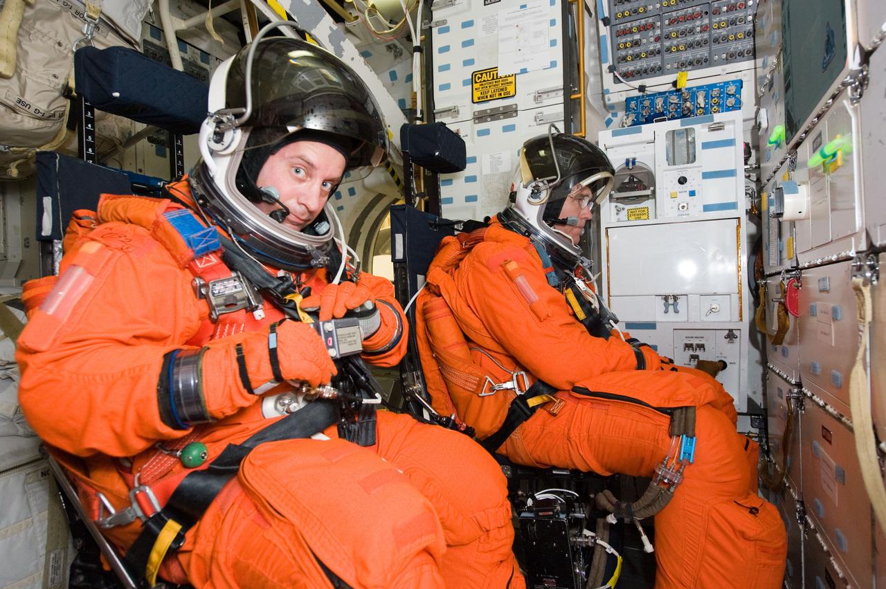 JSC2009-E-258479 (8 Dec. 2009) --- Attired in training versions of their shuttle launch and entry suits, astronauts Garrett Reisman (foreground) and Steve Bowen, both STS-132 mission specialists, participate in a training session on the middeck of the crew compartment trainer (CCT-2) in the Space Vehicle Mockup Facility at NASA?s Johnson Space Center.