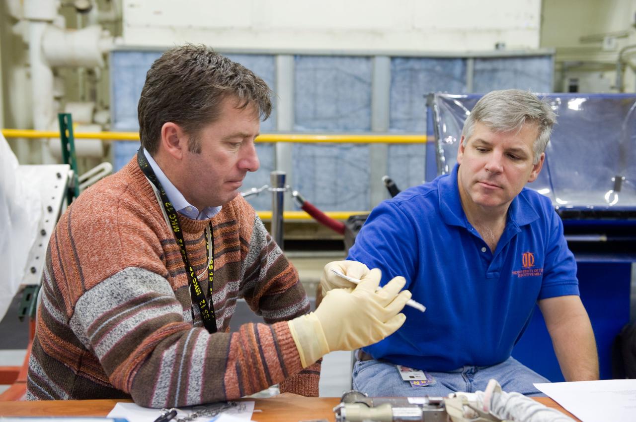 JSC2009-E-284893 (15 Dec. 2009) --- NASA astronaut Gregory H. Johnson (right), STS-134 pilot; and European Space Agency astronaut Roberto Vittori, mission specialist, participate in an EVA Thermal Protection System (TPS) overview training session in the TPS/ Precision Air Bearing Facility in the Space Vehicle Mock-up Facility at NASA?s Johnson Space Center.