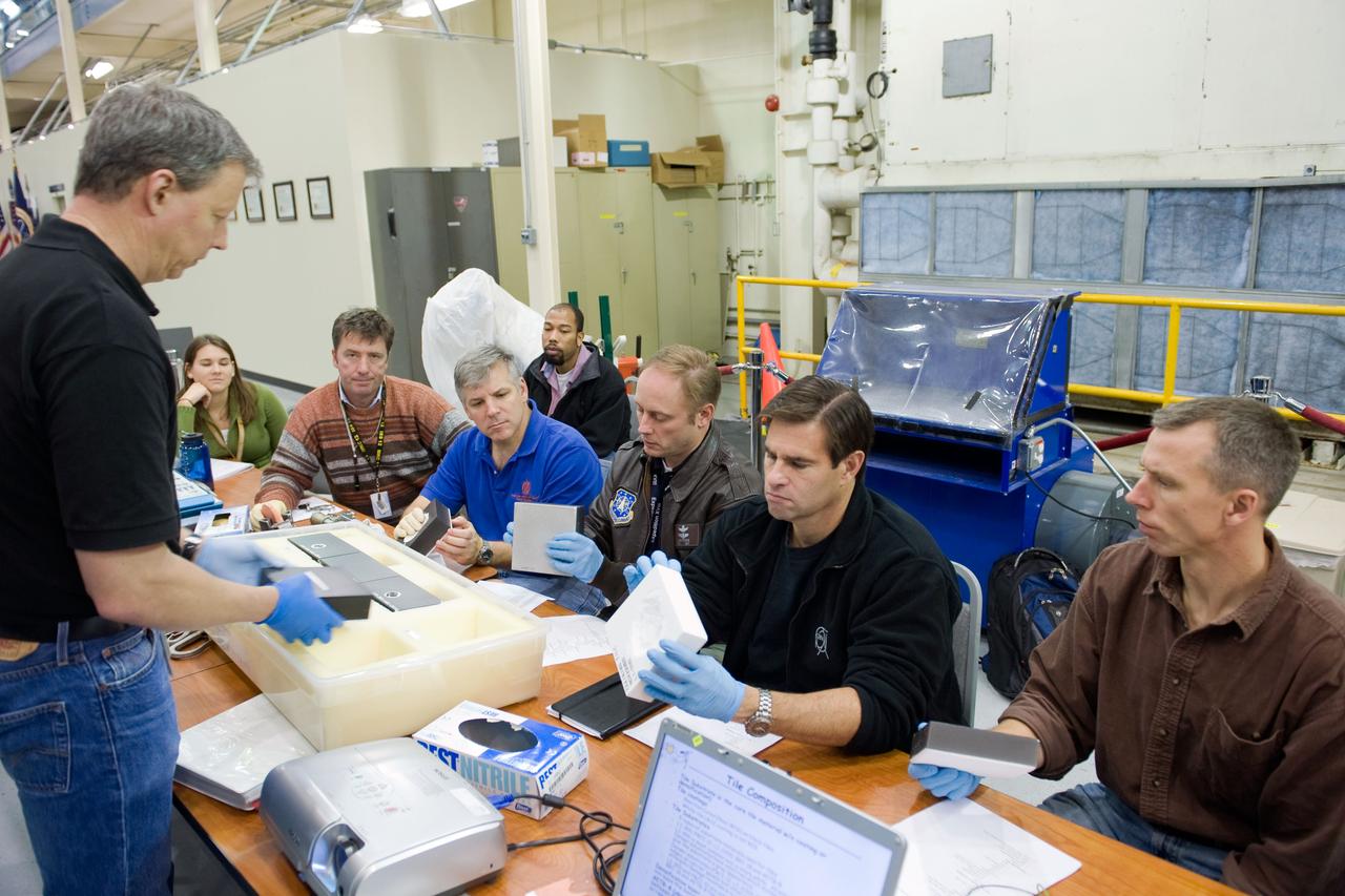 JSC2009-E-284897 (15 Dec. 2009) --- STS-134 crew members participate in an EVA Thermal Protection System (TPS) overview training session in the TPS/ Precision Air Bearing Facility in the Space Vehicle Mock-up Facility at NASA?s Johnson Space Center. Pictured from the right are NASA astronauts Andrew Feustel, Greg Chamitoff, Michael Fincke, all mission specialists; along with NASA astronaut Gregory H. Johnson, pilot; and European Space Agency astronaut Roberto Vittori, mission specialist. John Ray (left) assisted the crew members.