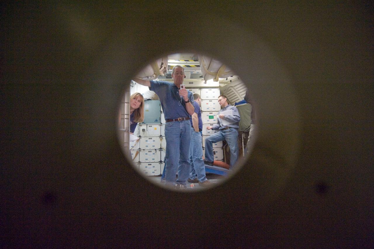 JSC2009-E-286955 (22 Dec. 2009) --- Viewed from a hatch window, STS-130 crew members participate in an ingress/egress timeline training session in a shuttle mock-up in the Space Vehicle Mock-up Facility at NASA's Johnson Space Center. Pictured from the left are astronauts Kathryn Hire, Stephen Robinson and Nicholas Patrick, all mission specialists. Crew trainer Adam Flagan (right) assisted the crew members.