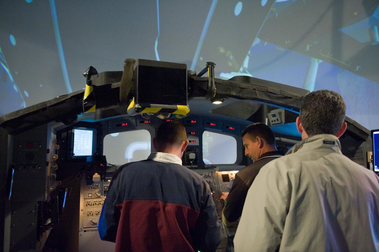 JSC2009-E-286962 (22 Dec. 2009) --- Astronauts Ken Ham (right background), STS-132 commander; Tony Antonelli (left), pilot; and Mike Good, mission specialist, participate in an exercise in the systems engineering simulator in the Avionics Systems Laboratory at NASA?s Johnson Space Center. The facility includes moving scenes of full-sized International Space Station components over a simulated Earth.