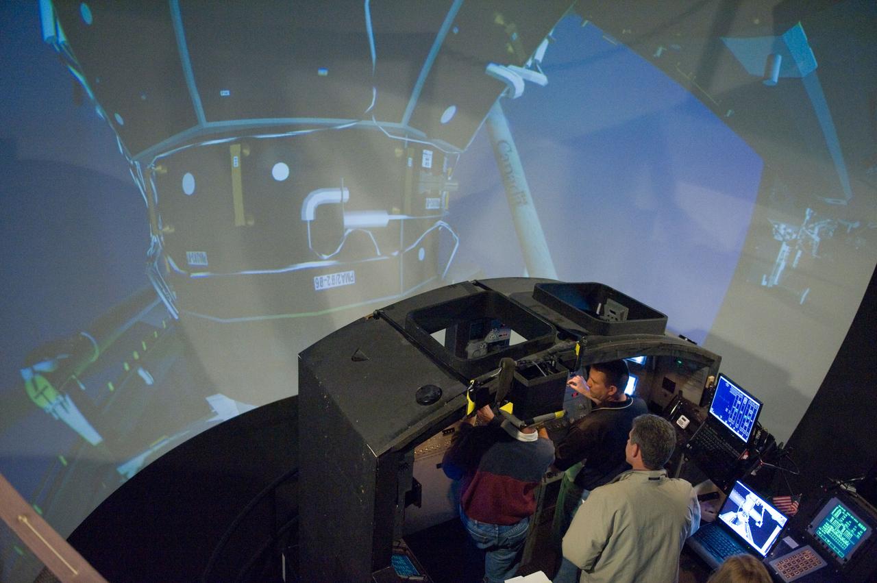 JSC2009-E-286972 (22 Dec. 2009) --- Astronauts Ken Ham (right background), STS-132 commander; Tony Antonelli (left), pilot; and Mike Good, mission specialist, participate in an exercise in the systems engineering simulator in the Avionics Systems Laboratory at NASA?s Johnson Space Center. The facility includes moving scenes of full-sized International Space Station components over a simulated Earth.
