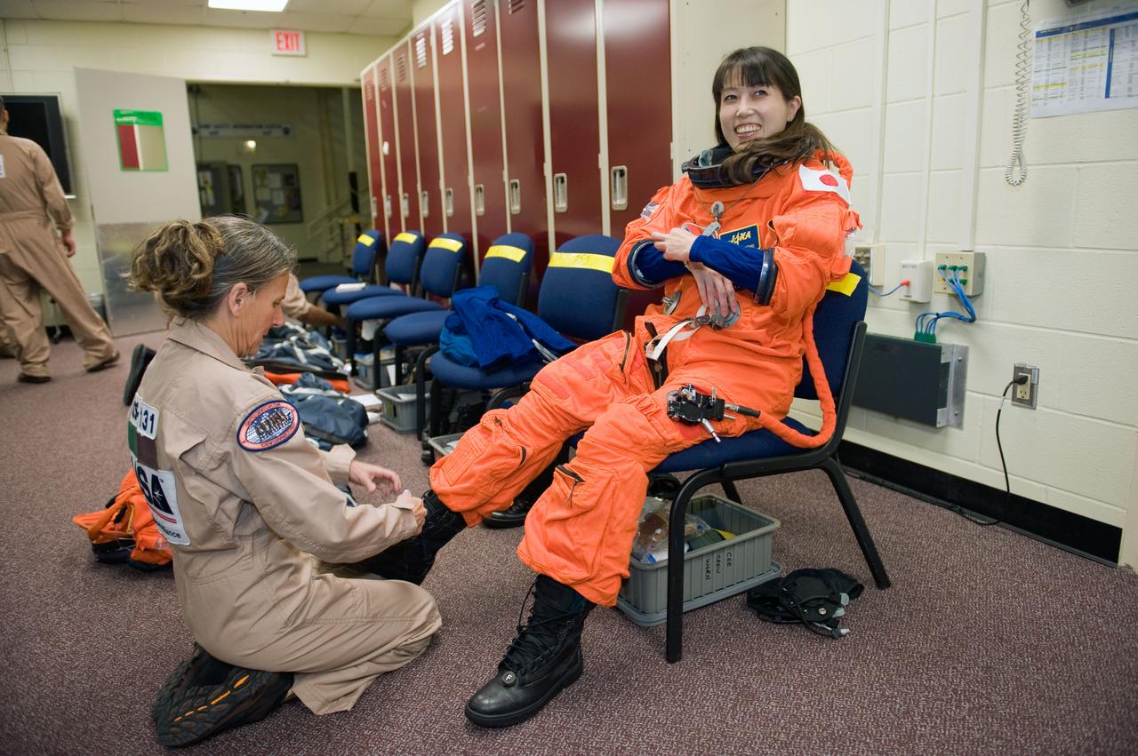 JSC2009-E-287960 (9 Dec. 2009) --- Japan Aerospace Exploration Agency (JAXA) astronaut Naoko Yamazaki, STS-131 mission specialist, dons a training version of her shuttle launch and entry suit in preparation for a training session in the Space Vehicle Mock-up Facility at NASA's Johnson Space Center. United Space Alliance suit technician Toni Cost-Davis assisted Yamazaki.