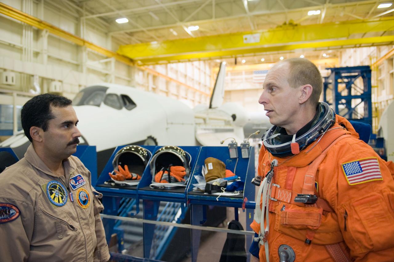 JSC2009-E-287978 (9 Dec. 2009) --- NASA astronaut Clayton Anderson (right), STS-131 mission specialist; and United Space Alliance suit technician Raymond Cuevas are pictured prior to the start of a training session in the Space Vehicle Mock-up Facility at NASA?s Johnson Space Center.