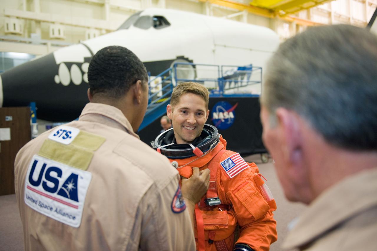 JSC2009-E-287979 (9 Dec. 2009) --- NASA astronaut James P. Dutton Jr. (facing camera), STS-131 pilot, gets help with the donning of a training version of his shuttle launch and entry suit in preparation for a training session in the Space Vehicle Mock-up Facility at NASA?s Johnson Space Center.