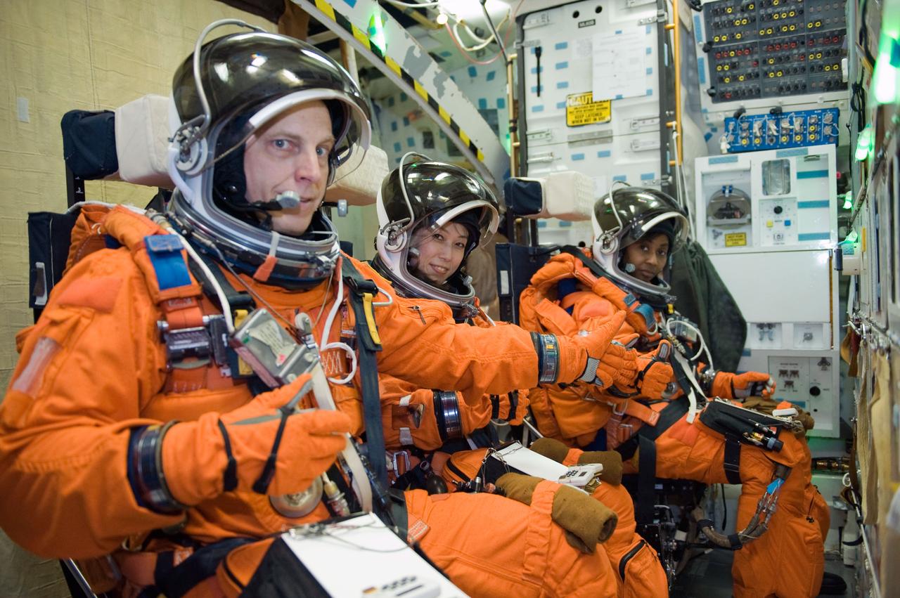JSC2009-E-287990 (9 Dec. 2009) --- NASA astronaut Clayton Anderson, Japan Aerospace Exploration Agency (JAXA) astronaut Naoko Yamazaki (center) and NASA astronaut Stephanie Wilson, all STS-131 mission specialists, participate in a training session in one of the full-scale trainers in the Space Vehicle Mock-up Facility at NASA's Johnson Space Center. Attired in training versions of their shuttle launch and entry suits, the three are seated on the middeck for a post insertion/de-orbit training session.