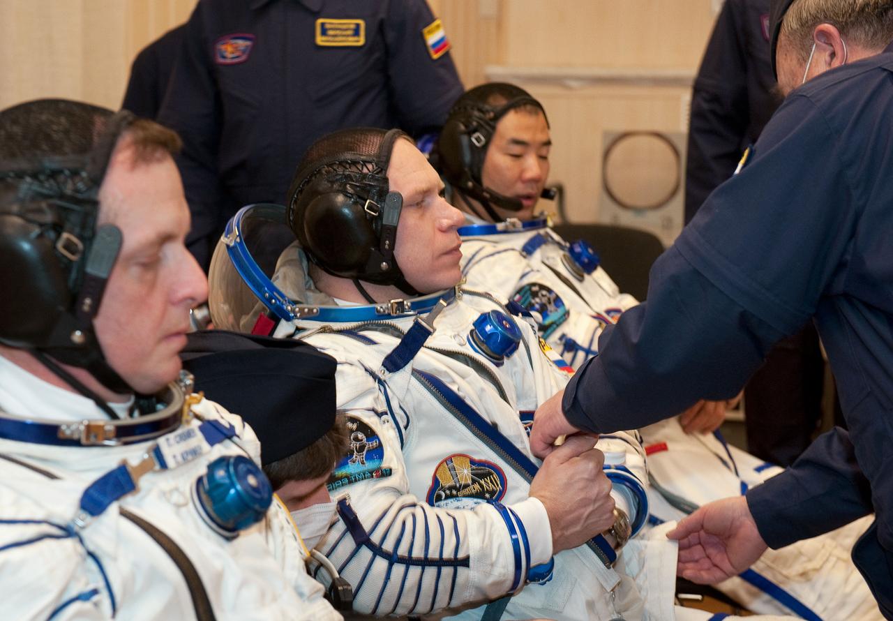 Expedition 22 Soyuz Commander Oleg Kotov of Russia, center, has his Russian Sokol suit prepared for launch while NASA Flight Engineer Timothy J. Creamer of the U.S., left, and Flight Engineer Soichi Noguchi of Japan wait at the Baikonur Cosmodrome in Baikonur, Kazakhstan, Sunday, Dec. 20, 2009. The Expedition 22 crew members launched in their Soyuz TMA-17 rocket from the Baikonur Cosmodrome in Kazakhstan on Monday, Dec. 21, 2009. (Photo Credit: NASA/Bill Ingalls)
