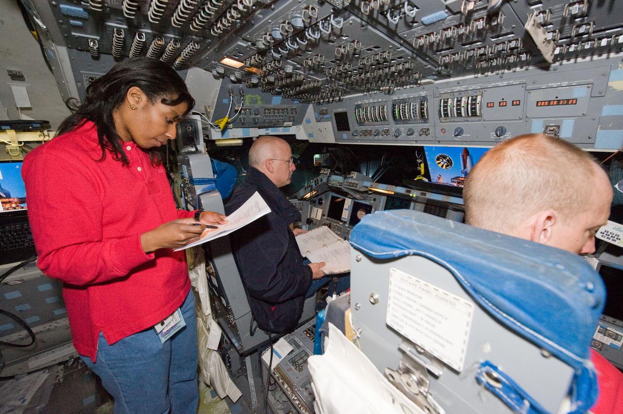 JSC2010-E-006713 (5 Jan. 2010) --- NASA astronauts Alan Poindexter (background), STS-131 commander; Clayton Anderson and Stephanie Wilson, both mission specialists, participate in an undocking timeline training session in the Guidance and Navigation Simulator in the Mission Simulation Development Facility at NASA's Johnson Space Center.