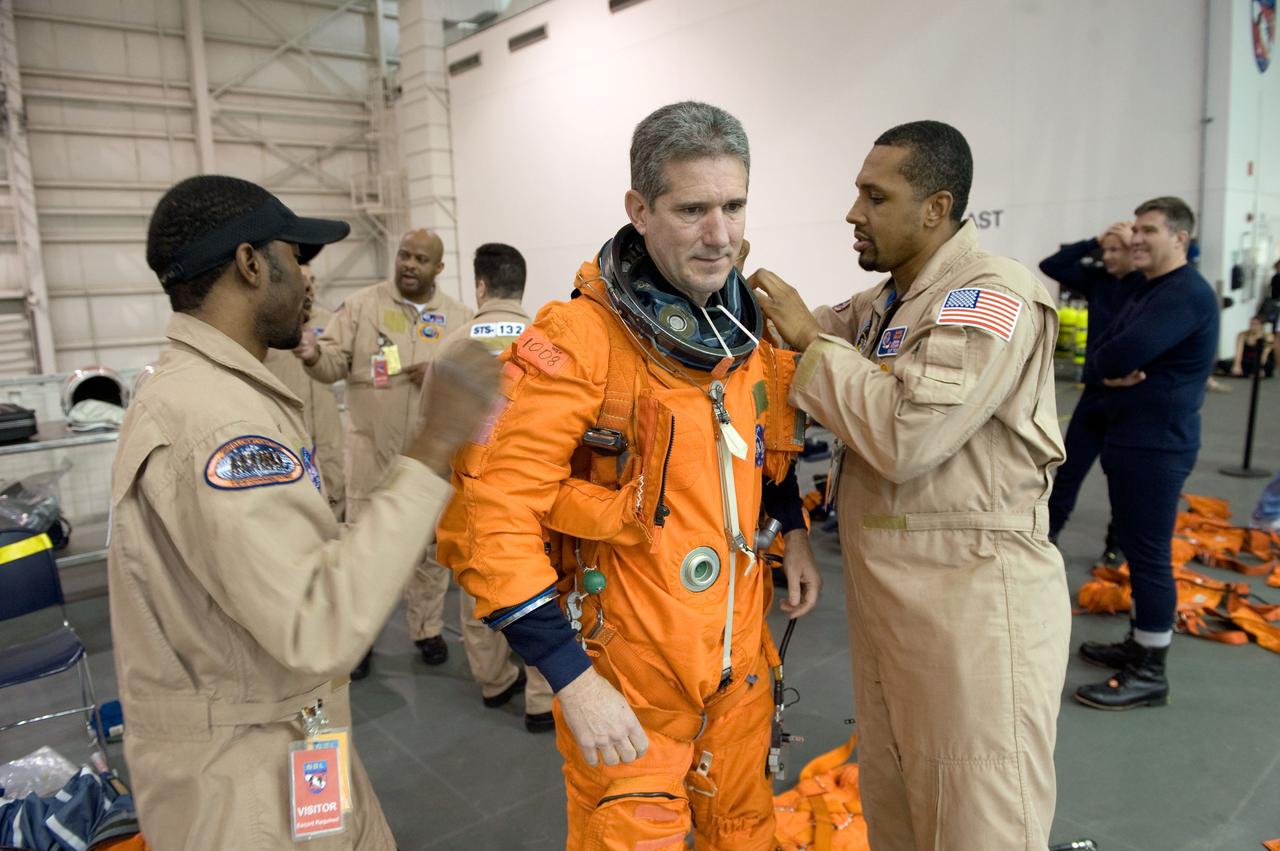 JSC2010-E-013686 (20 Jan. 2010) --- Astronaut Mike Good, STS-132 mission specialist, gets help with the donning of a training version of his shuttle launch and entry suit in preparation for a water survival training session in the Neutral Buoyancy Laboratory (NBL) near NASA's Johnson Space Center.