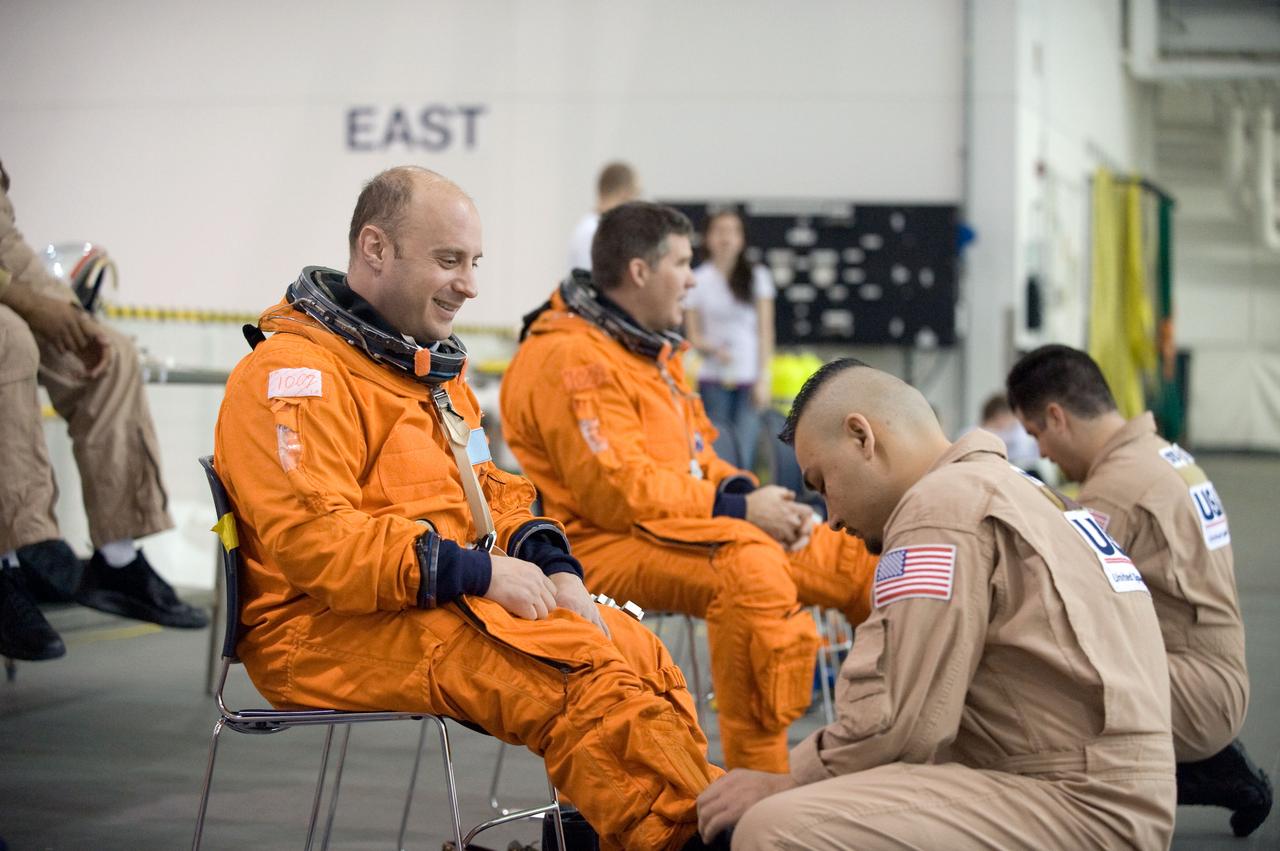 JSC2010-E-013690 (20 Jan. 2010) --- Astronauts Garrett Reisman (foreground) and Steve Bowen, both STS-132 mission specialists, get help with the donning of training versions of their shuttle launch and entry suits in preparation for a water survival training session in the Neutral Buoyancy Laboratory (NBL) near NASA's Johnson Space Center.