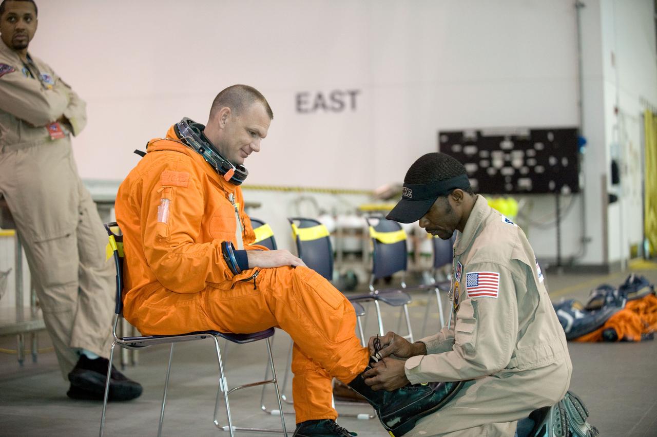 JSC2010-E-013706 (20 Jan. 2010) --- Astronaut Tony Antonelli, STS-132 pilot, gets help with the donning of a training version of his shuttle launch and entry suit in preparation for a water survival training session in the Neutral Buoyancy Laboratory (NBL) near NASA's Johnson Space Center.