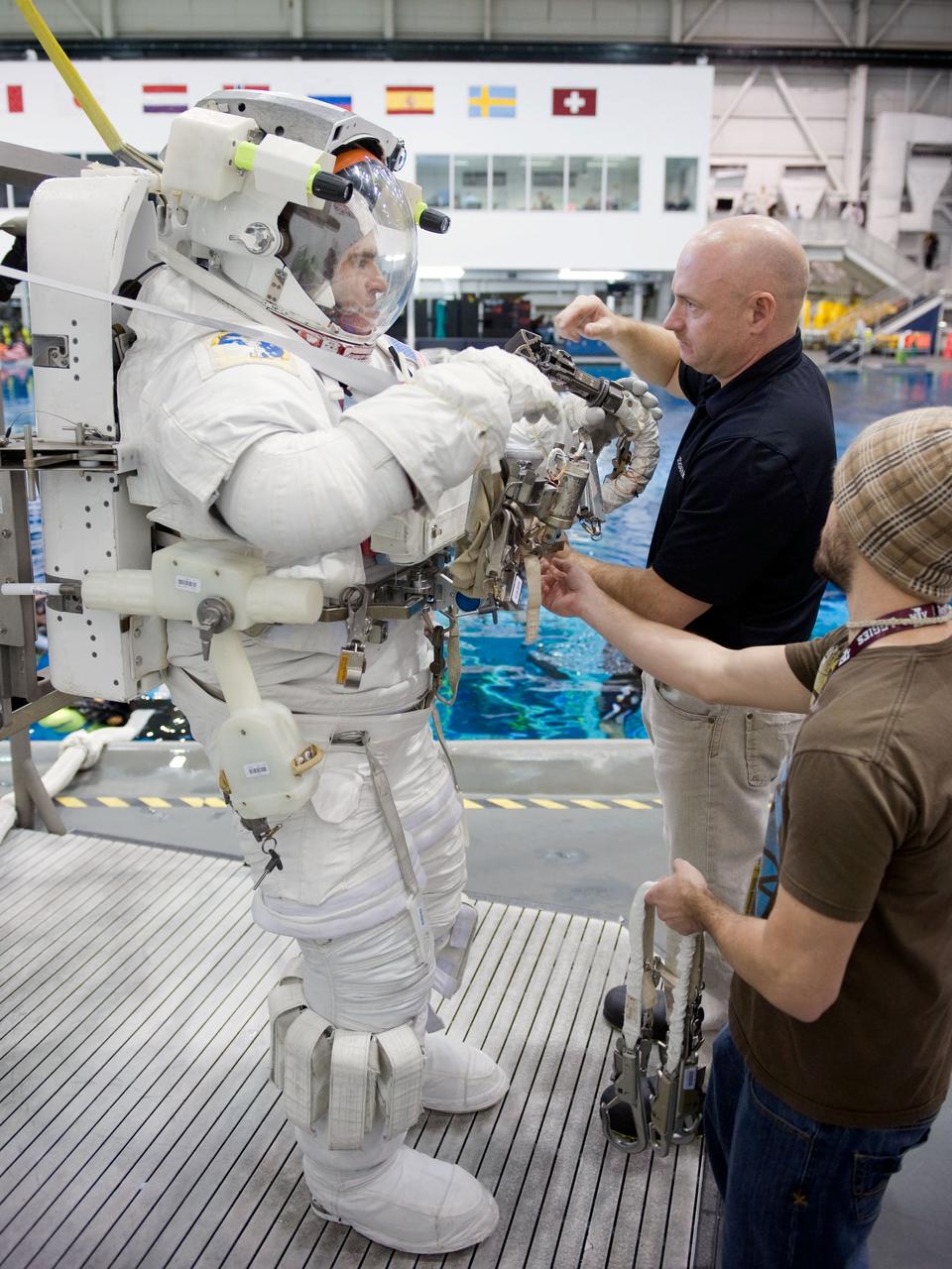 JSC2010-E-014287 (27 Jan. 2010) --- NASA astronaut Greg Chamitoff, STS-134 mission specialist, attired in a training version of his Extravehicular Mobility Unit (EMU) spacesuit, prepares for the start of a spacewalk training session in the waters of the Neutral Buoyancy Laboratory (NBL) near NASA's Johnson Space Center. Astronaut Mark Kelly, commander, assisted Chamitoff.