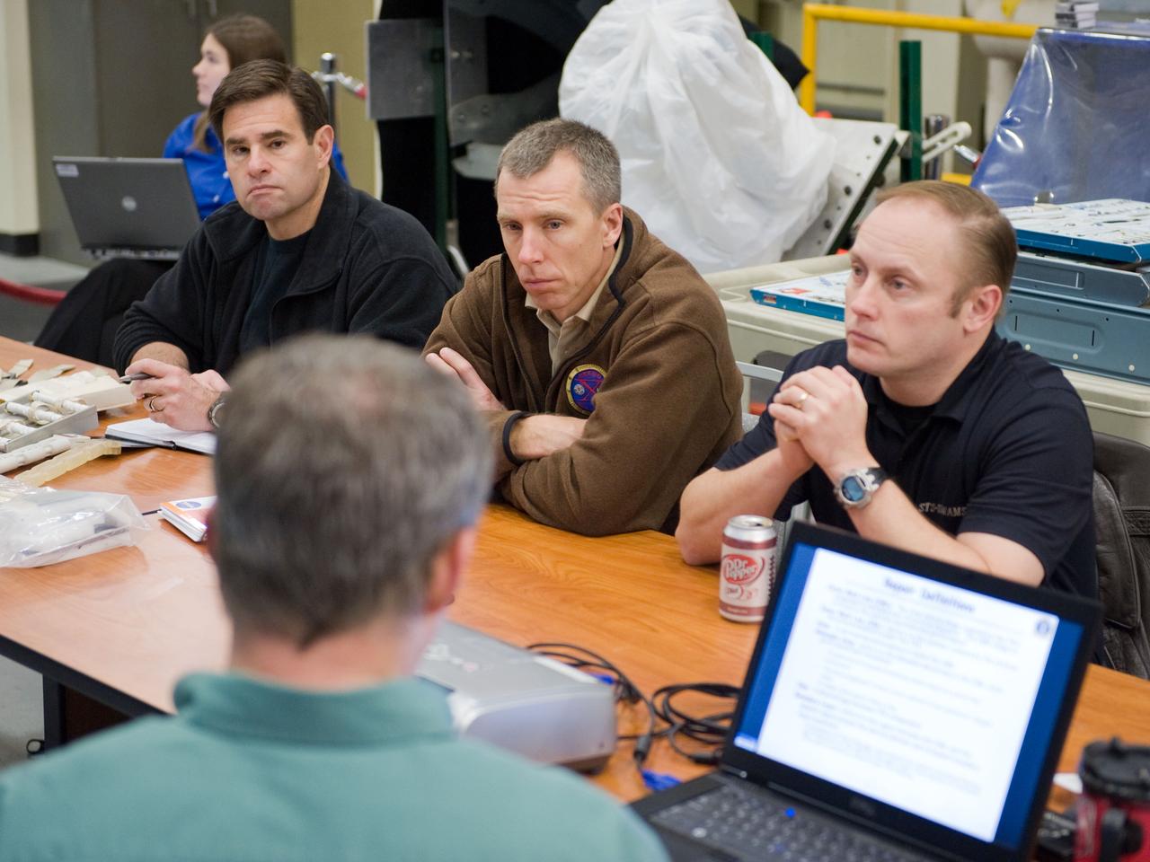 JSC2010-E-014761 (28 Jan. 2010) --- NASA astronauts Greg Chamitoff (left), Andrew Feustel and Michael Fincke, all STS-134 mission specialists, participate in an EVA tile repair training session in the Space Vehicle Mock-up Facility at NASA's Johnson Space Center.