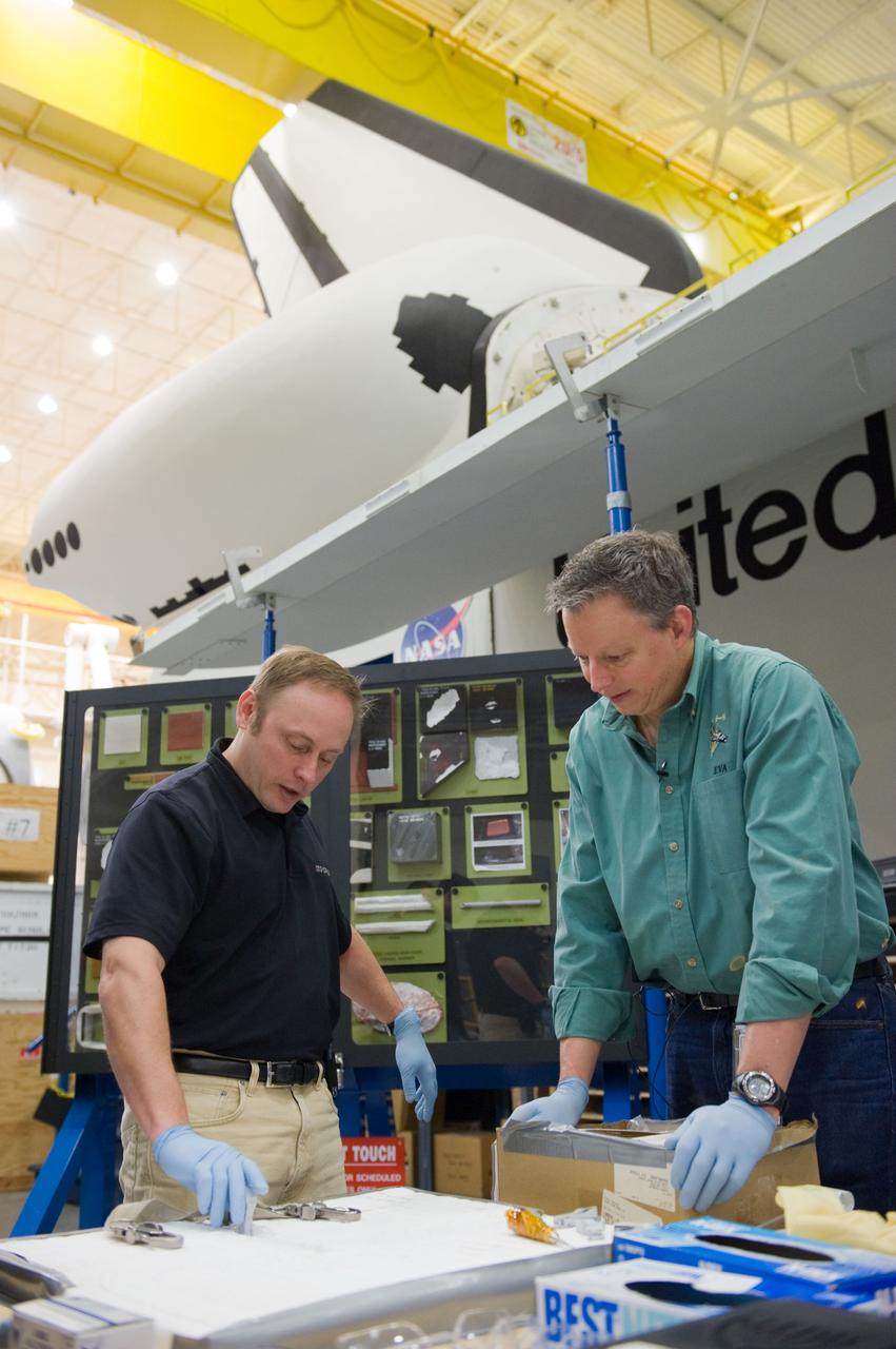 JSC2010-E-014766 (28 Jan. 2010) --- NASA astronaut Michael Fincke (left), STS-134 mission specialist, participates in an EVA tile repair training session in the Space Vehicle Mock-up Facility at NASA's Johnson Space Center. Instructor John Ray assisted Fincke.