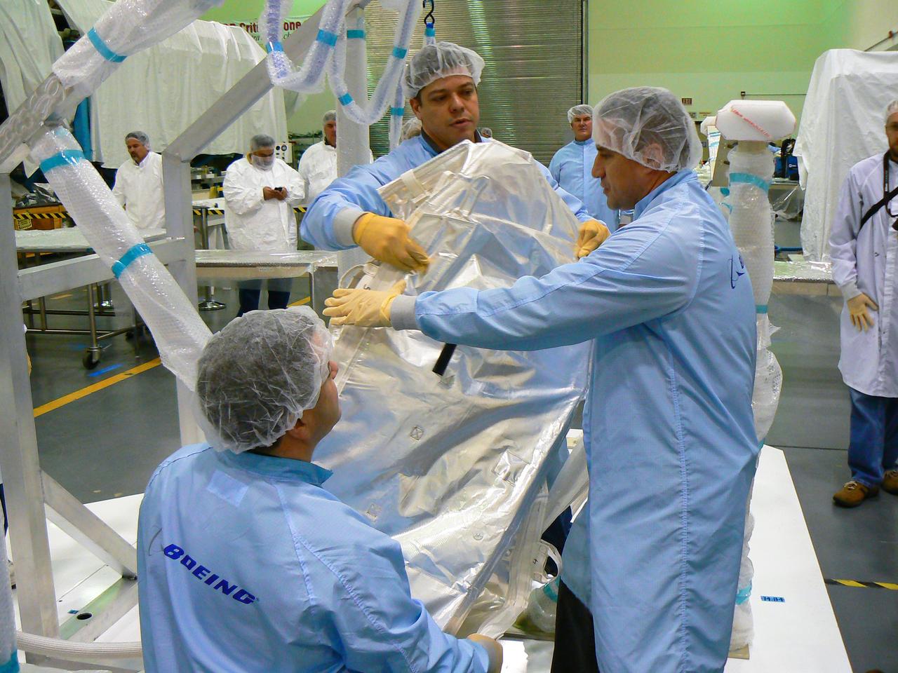 JSC2010-E-014774 (15 Jan. 2010) --- At Marshall Space Center?s building 4708 in the high-bay clean room, astronauts George Zamka (right), STS-130 commander; along with astronauts Nicholas Patrick (foreground) and Robert Behnken, both mission specialists, are seen with a 1G stand that simulates geometrically the interfaces of the ammonia hoses between node 3 and the U.S. lab on orbit. The three crew members are pulling the ammonia blanket from their EVA bag to verify how they would perform the installation procedure on orbit.