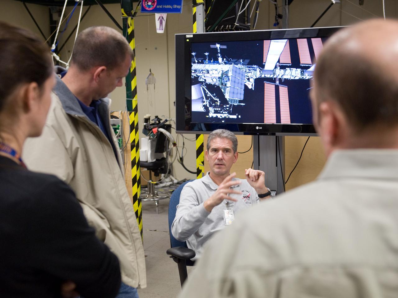 JSC2010-E-014950 (28 Jan. 2010) --- NASA astronauts Michael Good (facing camera), Garrett Reisman (right), both STS-132 mission specialists; and Tony Antonelli, pilot, use the virtual reality lab in the Space Vehicle Mock-up Facility at NASA's Johnson Space Center to train for some of their duties aboard the space shuttle and space station. This type of computer interface, paired with virtual reality training hardware and software, helps to prepare crew members for dealing with space station elements.