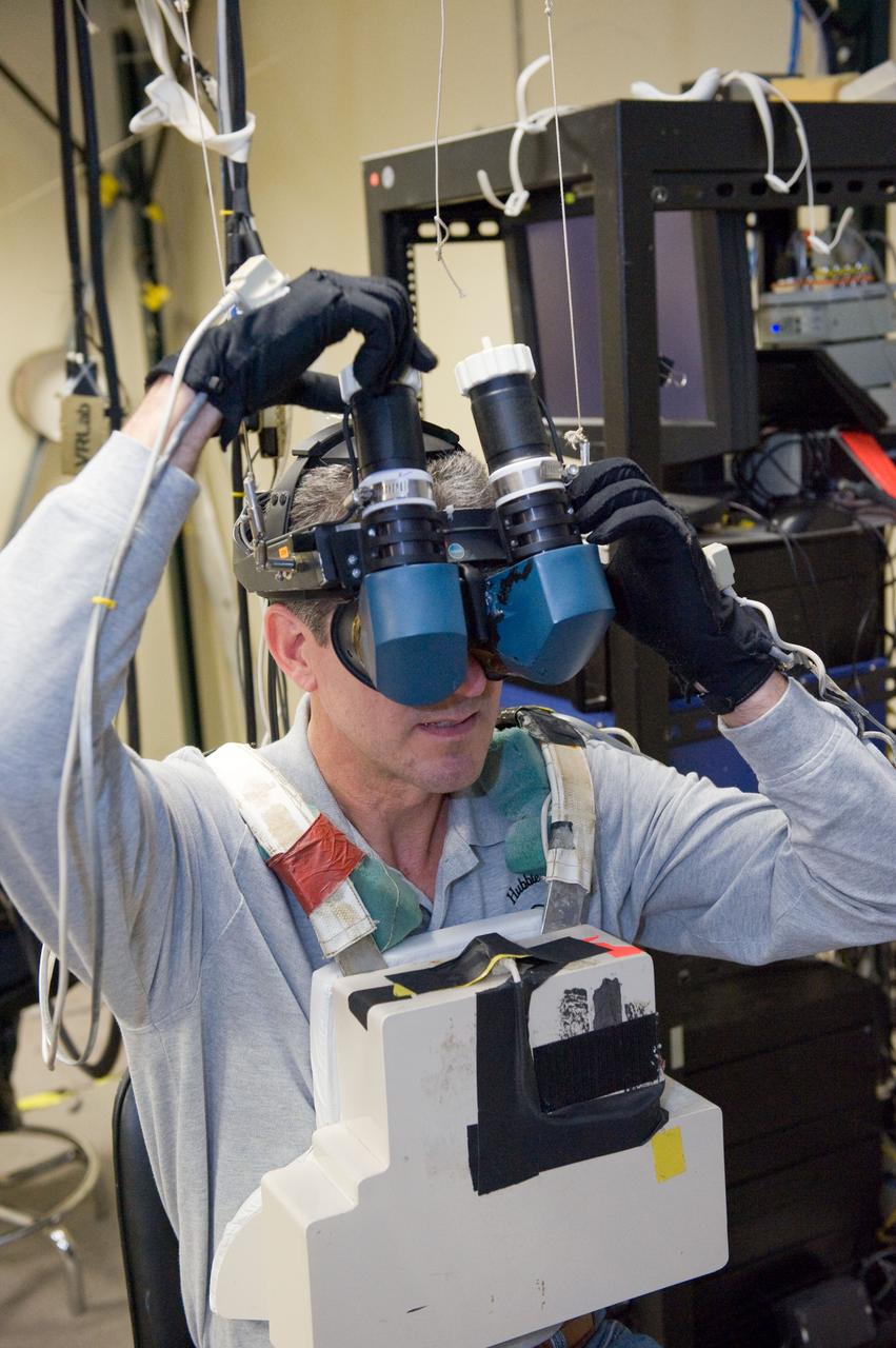 JSC2010-E-014958 (28 Jan. 2010) --- NASA astronaut Michael Good, STS-132 mission specialist, uses virtual reality hardware in the Space Vehicle Mock-up Facility at NASA's Johnson Space Center to rehearse some of his duties on the upcoming mission to the International Space Station. This type of virtual reality training allows the astronauts to wear a helmet and special gloves while looking at computer displays simulating actual movements around the various locations on the station hardware with which they will be working.