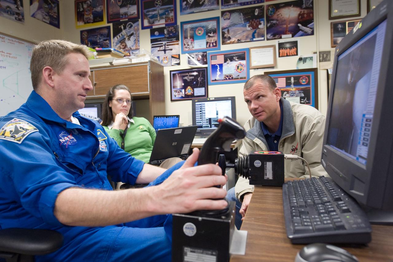 JSC2010-E-014963 (28 Jan. 2010) --- NASA astronauts Ken Ham (left), STS-132 commander; and Tony Antonelli, pilot, use the virtual reality lab in the Space Vehicle Mock-up Facility at NASA's Johnson Space Center to train for some of their duties aboard the space shuttle and space station. This type of computer interface, paired with virtual reality training hardware and software, helps to prepare crew members for dealing with space station elements.