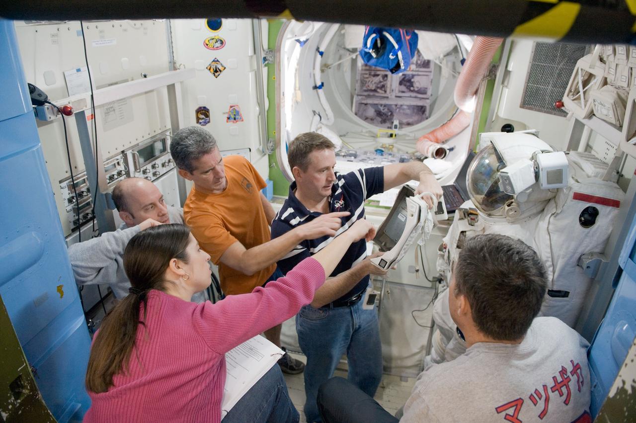 JSC2010-E-015331 (27 Jan. 2010) --- STS-132 crew members work with an Extravehicular Mobility Unit (EMU) spacesuit during a training session in an International Space Station mock-up/trainer in the Space Vehicle Mock-up Facility at NASA's Johnson Space Center. Pictured are NASA astronaut Ken Ham (center), commander; along with astronauts Garrett Reisman (left), Michael Good and Steve Bowen (right), all mission specialists.
