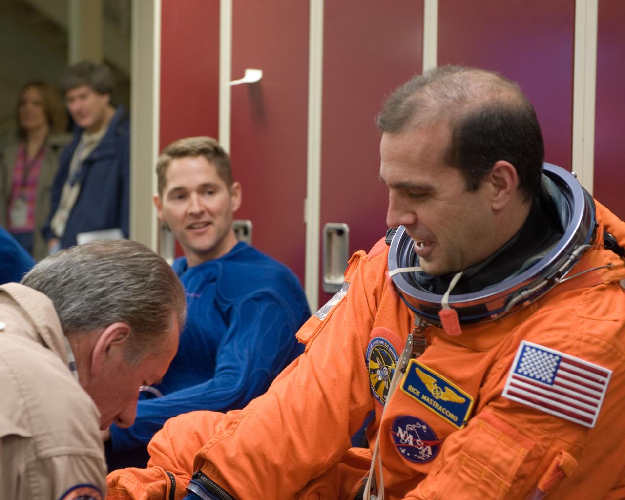 JSC2010-E-017714 (29 Jan. 2010) --- NASA astronauts Rick Mastracchio (foreground), STS-131 mission specialist; and James P. Dutton Jr., pilot, don training versions of their shuttle launch and entry suits in preparation for an ingress/egress training session in the Space Vehicle Mock-up Facility at NASA's Johnson Space Center. United Space Alliance suit technician Jim Cheatham assisted the crew members.