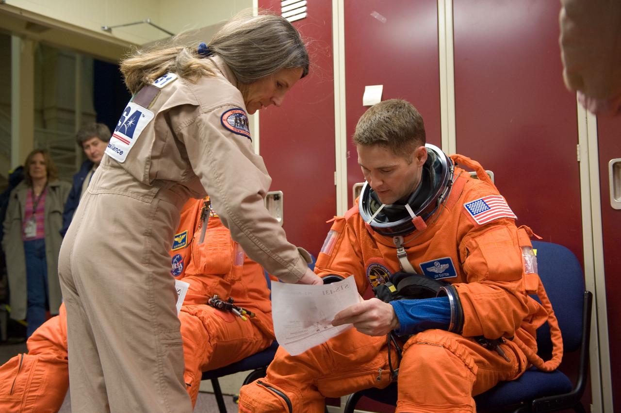 JSC2010-E-017719 (29 Jan. 2010) --- NASA astronaut James P. Dutton Jr., STS-131 pilot, attired in a training version of his shuttle launch and entry suit, prepares for an ingress/egress training session in the Space Vehicle Mock-up Facility at NASA's Johnson Space Center. United Space Alliance suit technician Toni Cost-Davis assisted Dutton.